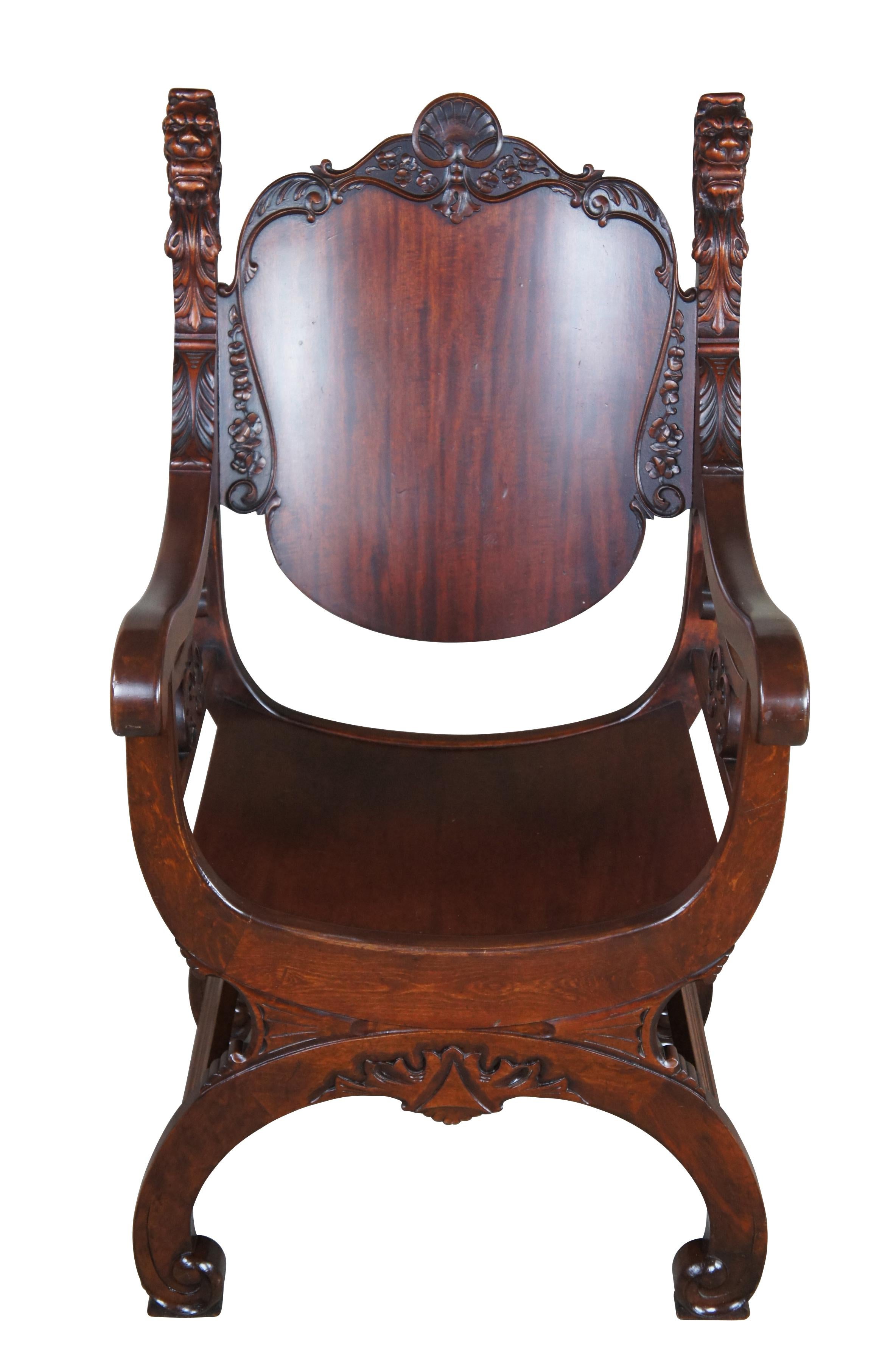 Antique Renaissance Revival throne armchair.  Made of mahogany featuring curule / savonarola styling with carved lion head finials flanking a shield shaped back with shell crest and floral / acanthus accents, supported by curved seat over serpentine