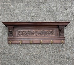 Antiguo perchero de pared renacentista con esculturas de leones y ganchos de bronce