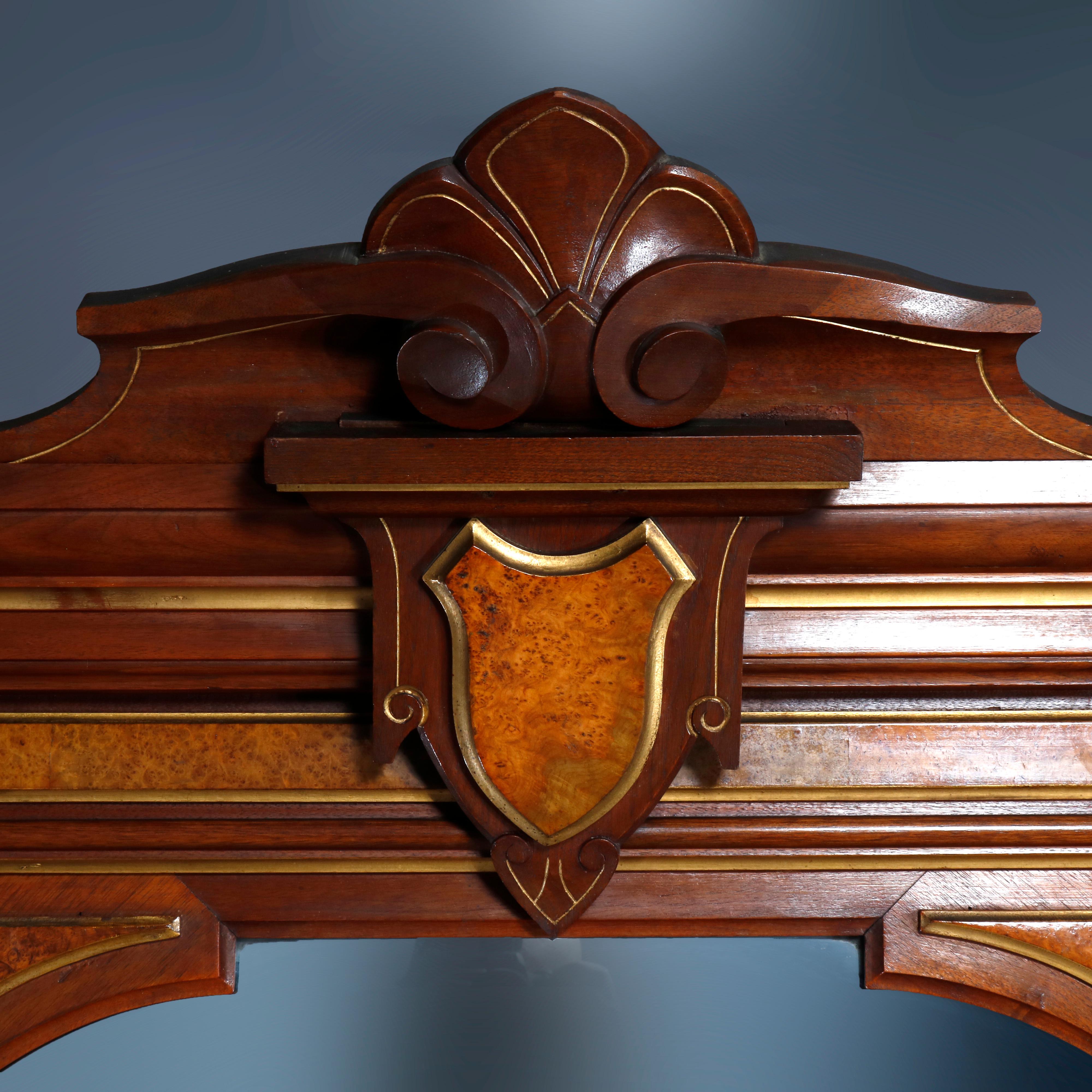 An antique Renaissance Revival pier mirror offers carved walnut frame having stylized shell crest surmounting shield reserve and having burl insets and gilt trimming throughout over shaped marble top base, circa 1880

Measures: 116.5