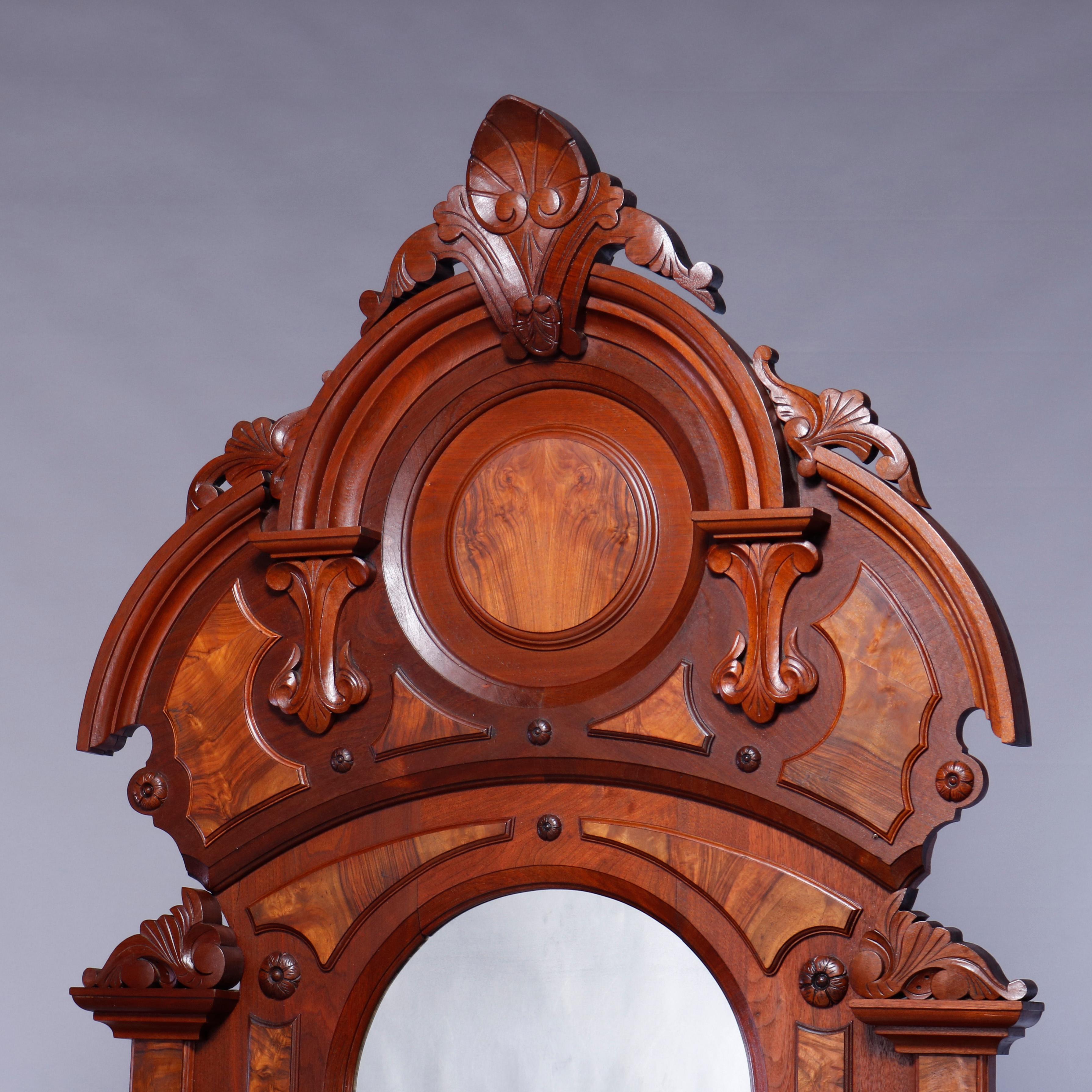 An antique Renaissance Revival dresser offers walnut and burl paneled construction with tall dressing mirror having shaped crest with carved cartouche with flanking foliate elements and candle stands surmounting drop center marble top chest of