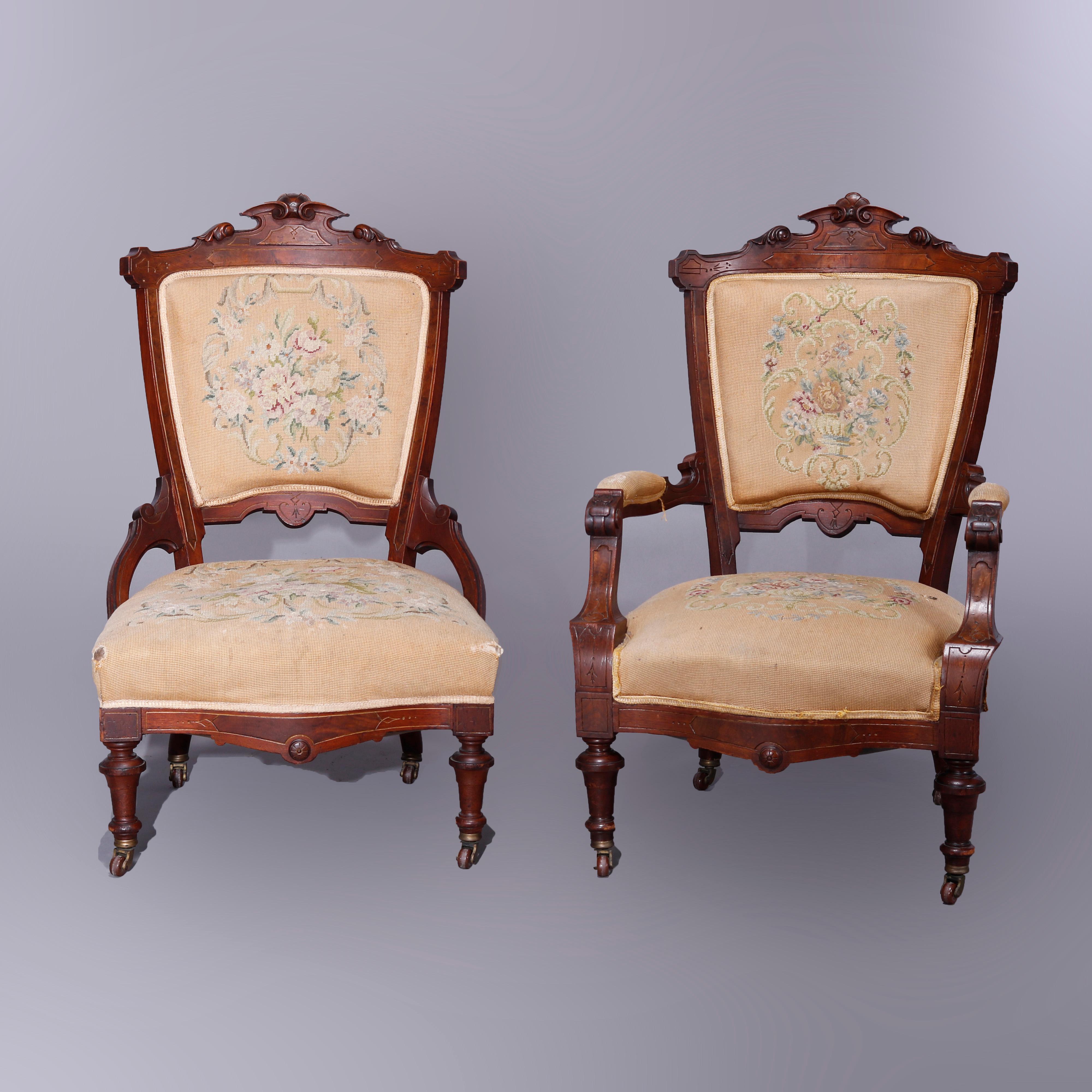 An antique pair of Renaissance Revival parlor chairs offers walnut and burl construction with carved crest having foliate elements and surmounting floral needlepoint back and seat, raised on balustrade legs, set includes gentleman's armchair and