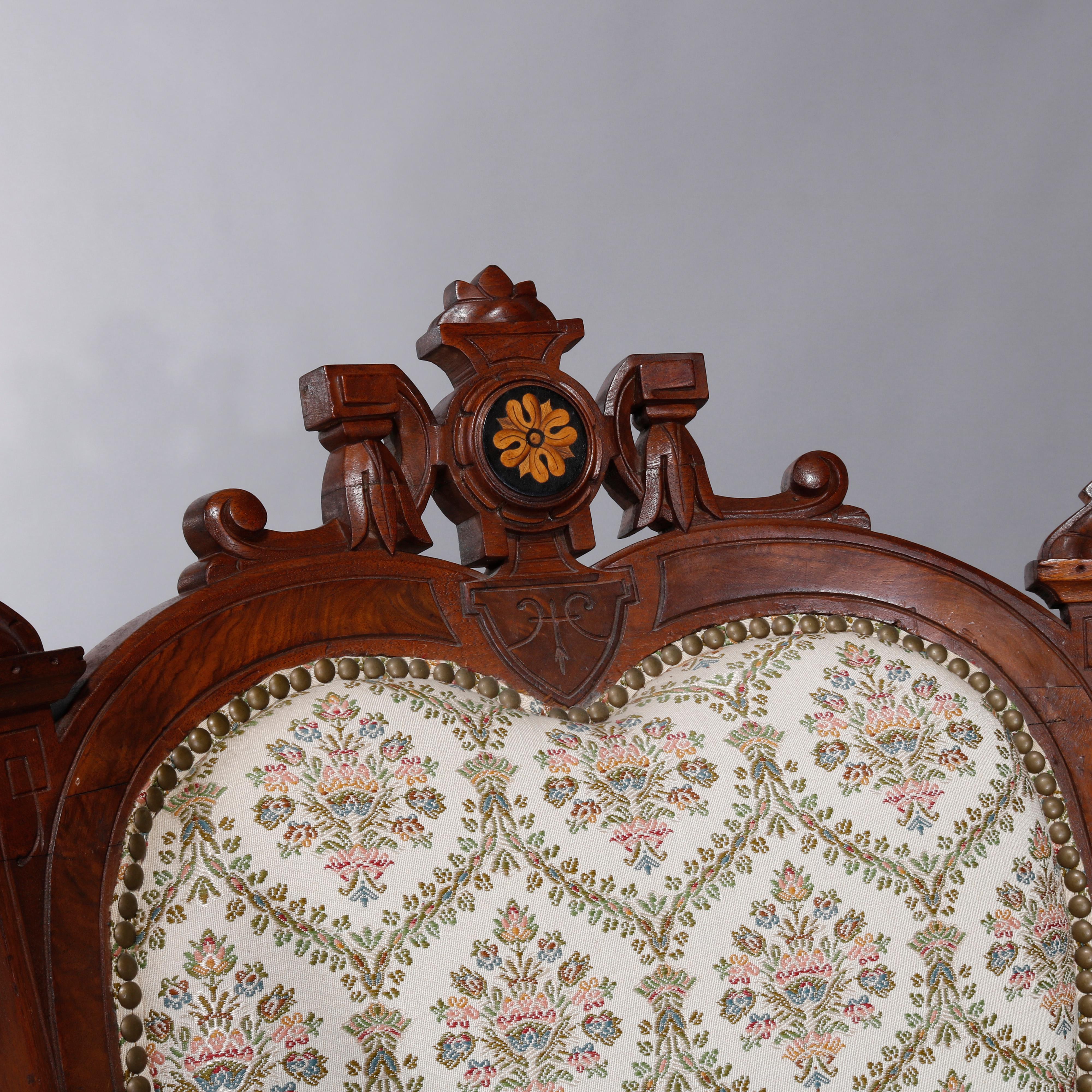 An antique pair of Renaissance Revival parlor armchairs offer walnut frames with burl insets having heart form backs with carved crest with central patera marquetry element, scroll form arms flank seats raised on balustrade legs, c1880

Measures: