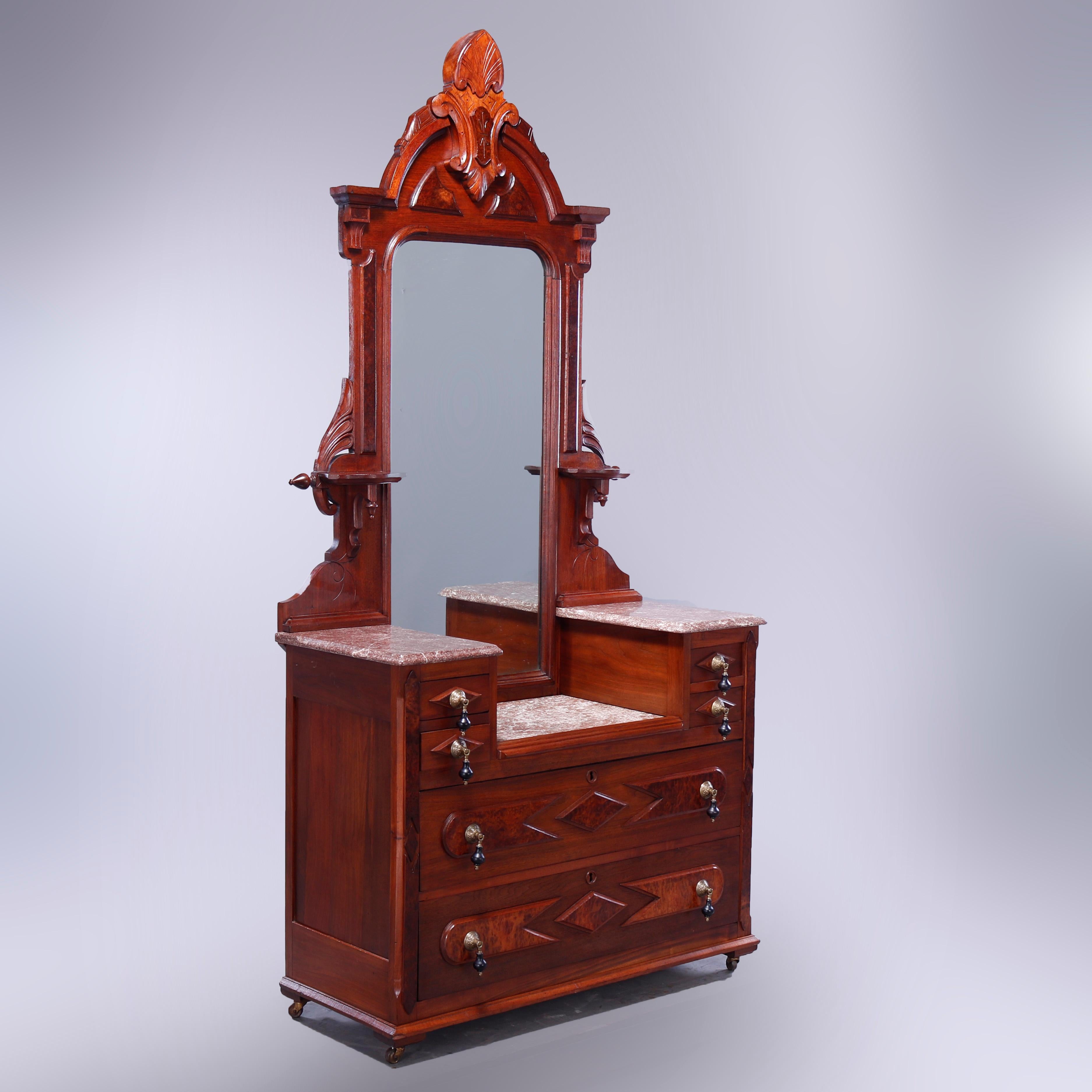 An antique Renaissance Revival dresser offers walnut construction with drop-center dressing mirror having carved stylized palmette cartouche with flanking spire finials over frame with flanking candle stands and scroll form corbels surmounting