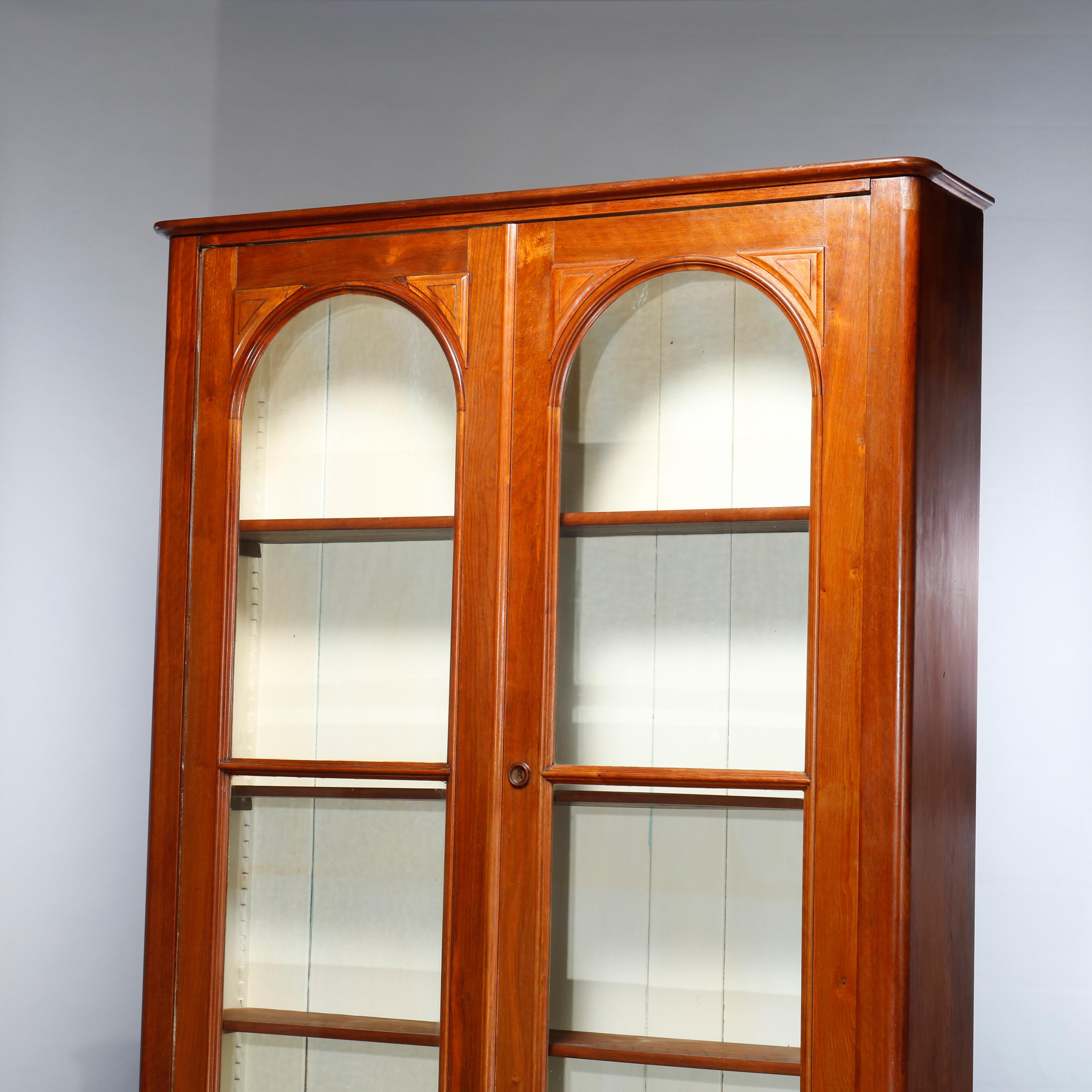 An antique Renaissance Revival bookcase offers walnut construction with double doors with arced glass windows over lower with drawers having carved pulls, c1880.
  

Measures: 92