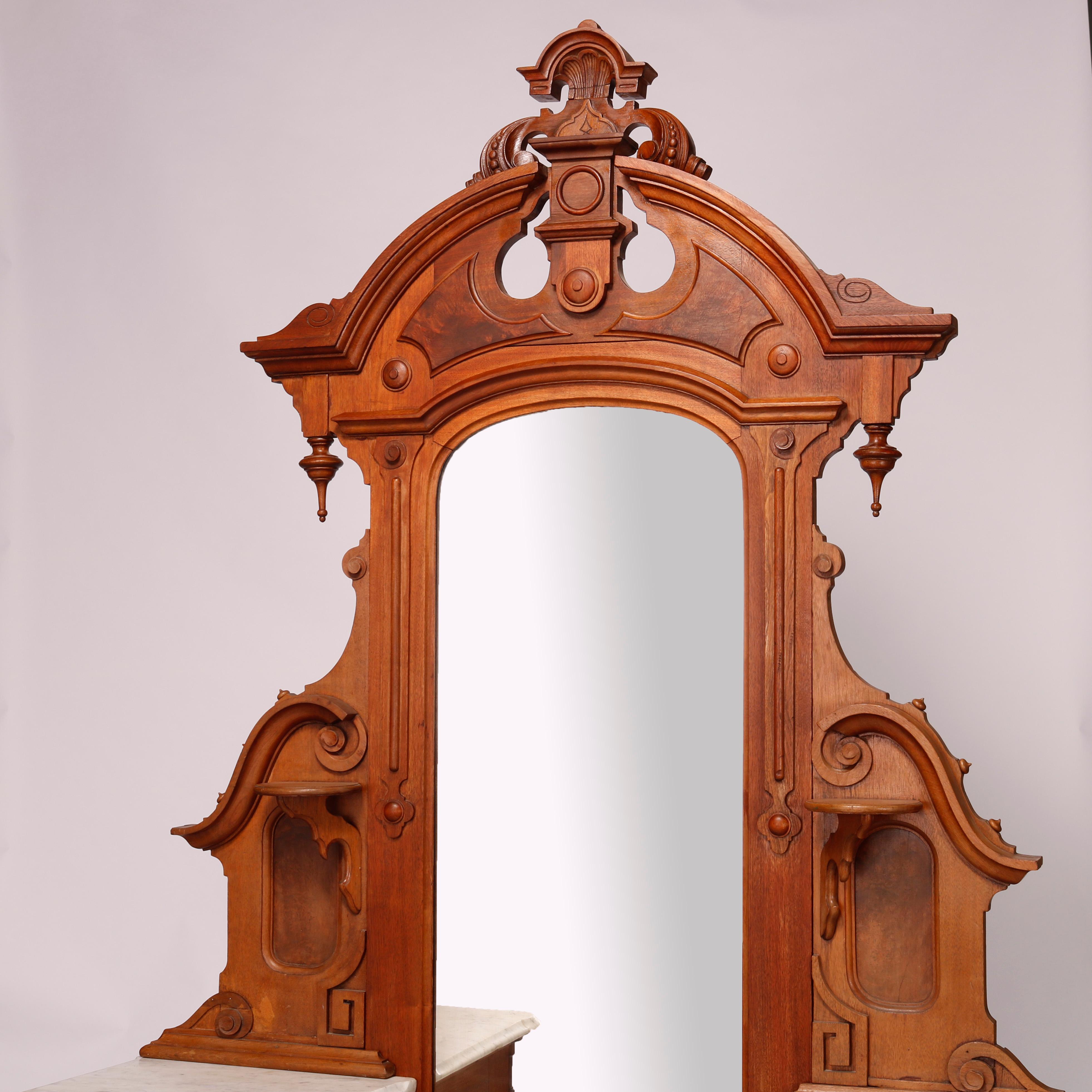 An antique Renaissance Revival dresser offers walnut and burl construction with dressing mirror having carved foliate cartouche and drop finials over frame with candle stands and flanking scroll corbels surmounting drop-center case having marble