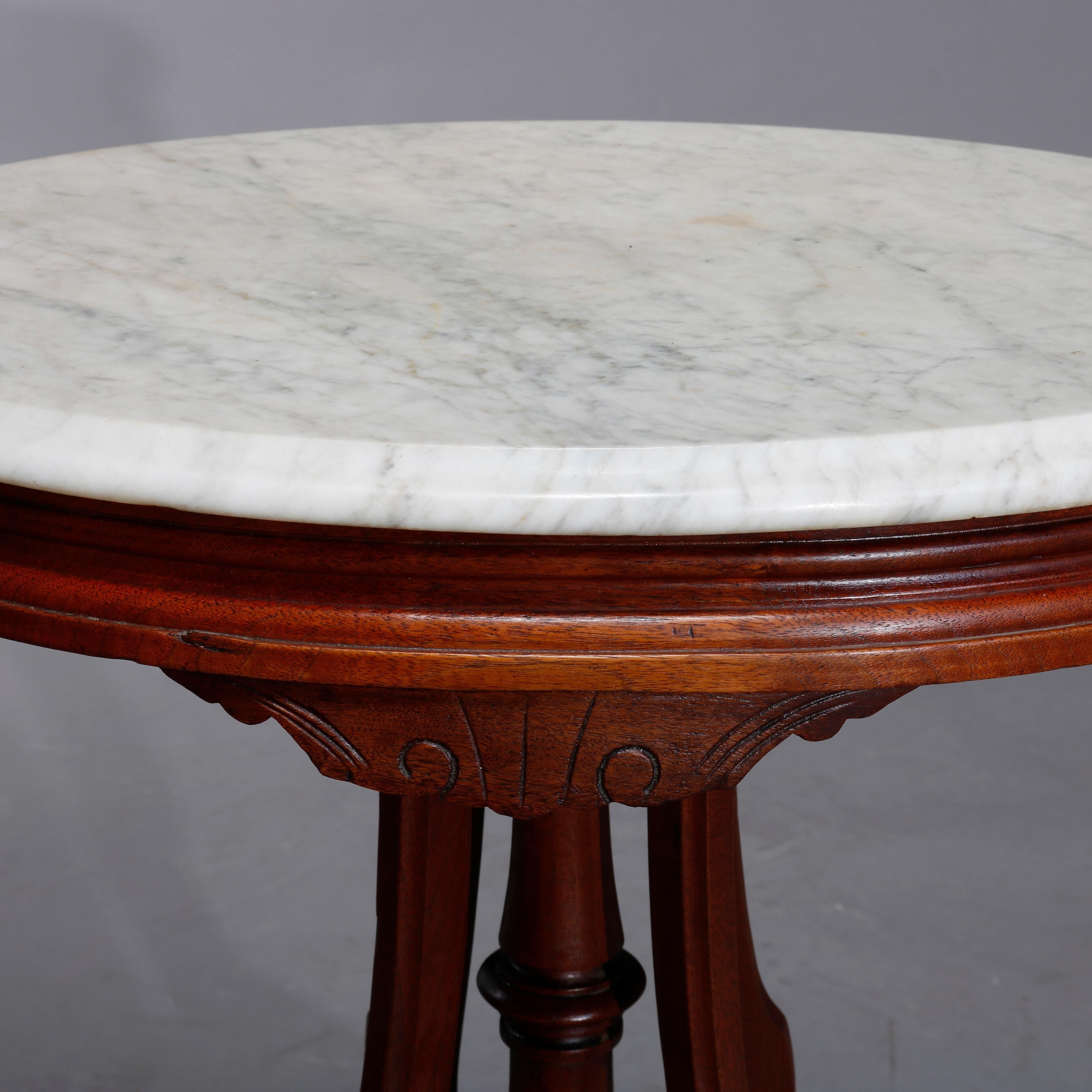 An antique Renaissance Revival side table offers oval form with beveled marble top surmounting carved walnut base having skirt with scroll incised element raised on cabriole legs with central turned column, c1890

Measures: 29.5