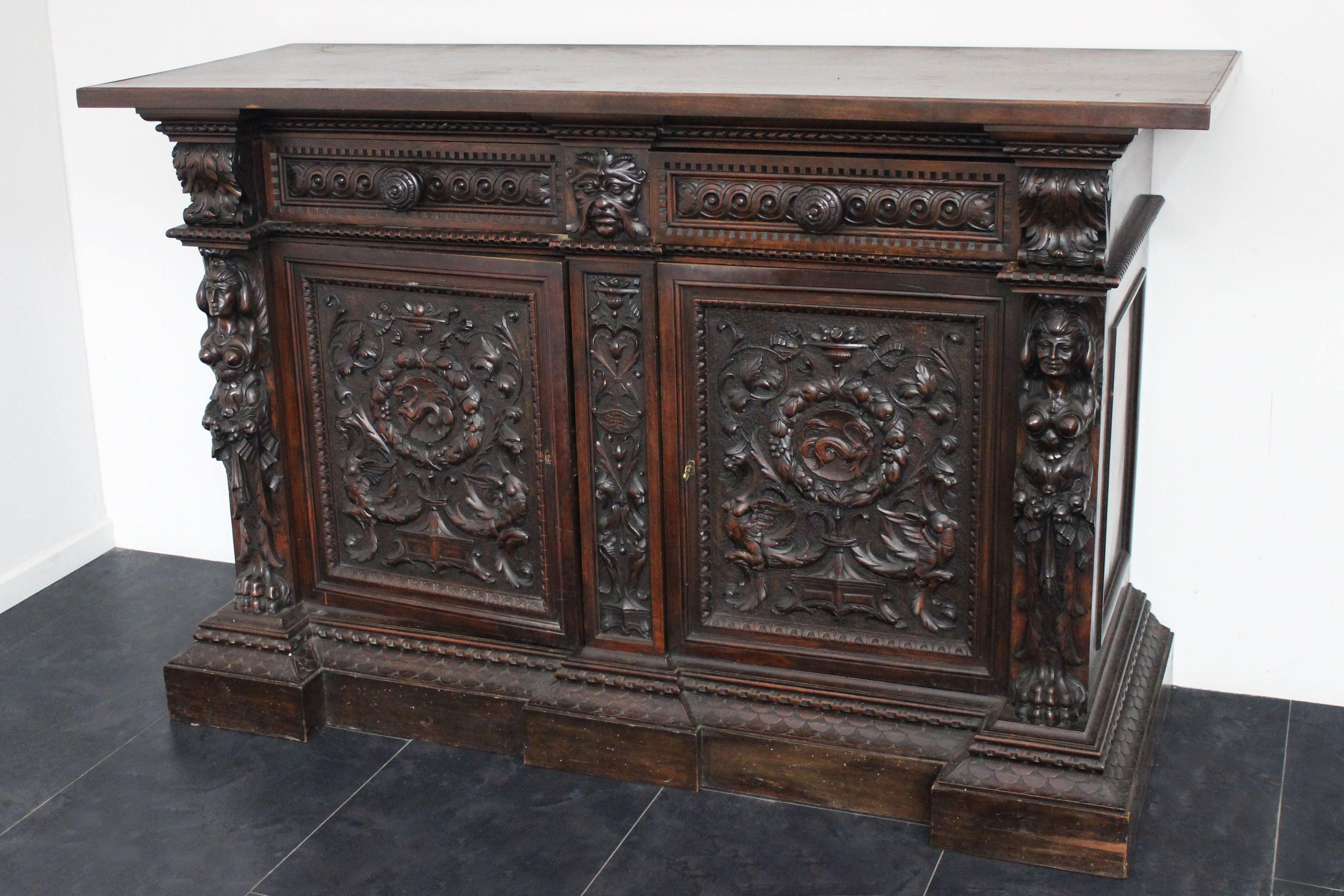 Neo-Renaissance style sideboard, solid walnut wood, dating back to the turn of the 19th and 20th centuries, richly handmade with anthropomorphic sculptures and bas-reliefs, finely carved with geometric and floral motifs. 
Packaging with bubble wrap