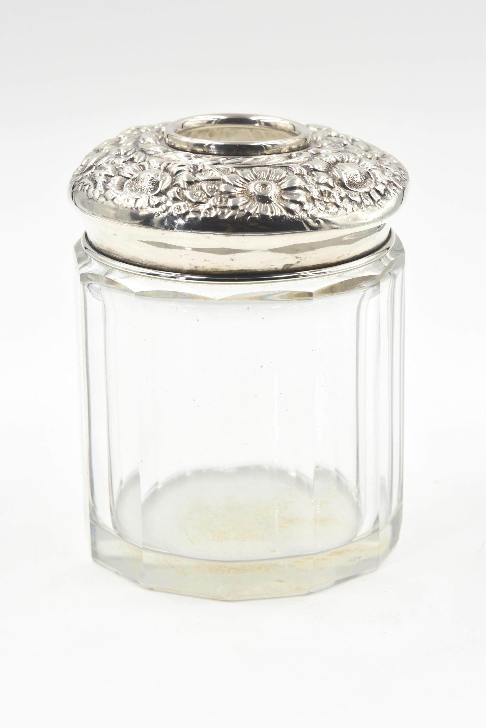 Early 20th century R. Blackinton & Co. hair receiver jar featuring a high relief sterling silver repose floral design lid that has a hole to insert hair on a 12 panel glass jar. This jar would be look beautiful on a dressing table or in a bathroom.