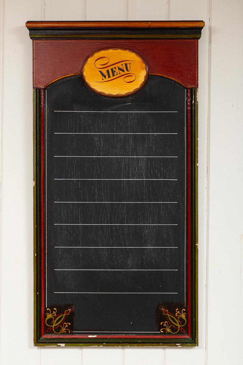 Tablero de tiza antiguo para menús de restaurante, hacia 1920. Un encantador marco pintado a mano rodea una pizarra de tiza forrada. Recuerda a los carteles de los bistrós franceses.