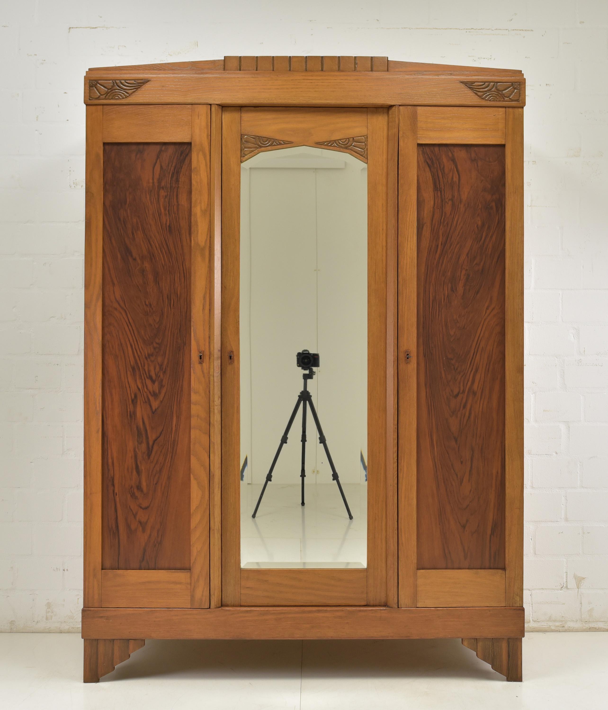 Über das Stück:

    Epoche: 1930er Jahre
    Herkunft: Unbekannt
    Stil: Art Deco
    MATERIALIEN: Teilweise massive Eiche, Palisanderfurnier, Spiegel, Glas, Beschläge
    Abmessungen:
        Höhe: 200 cm (78,74 Zoll)
        Breite: 141 cm