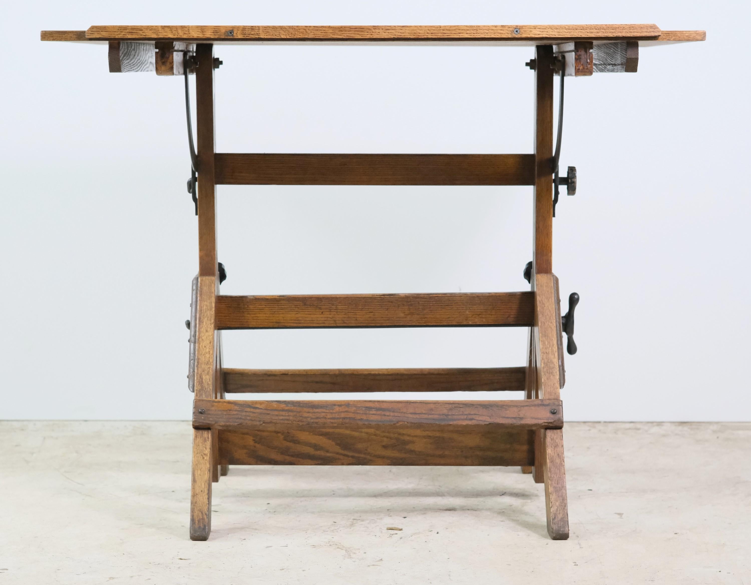 Early 20th century adjustable dark tone oak architect's drafting table with a new oak top and all original black steel hardware. Refinished and restored. Made by Hamilton Manufacturing Co. This can be seen at our 302 Bowery location in NoHo in