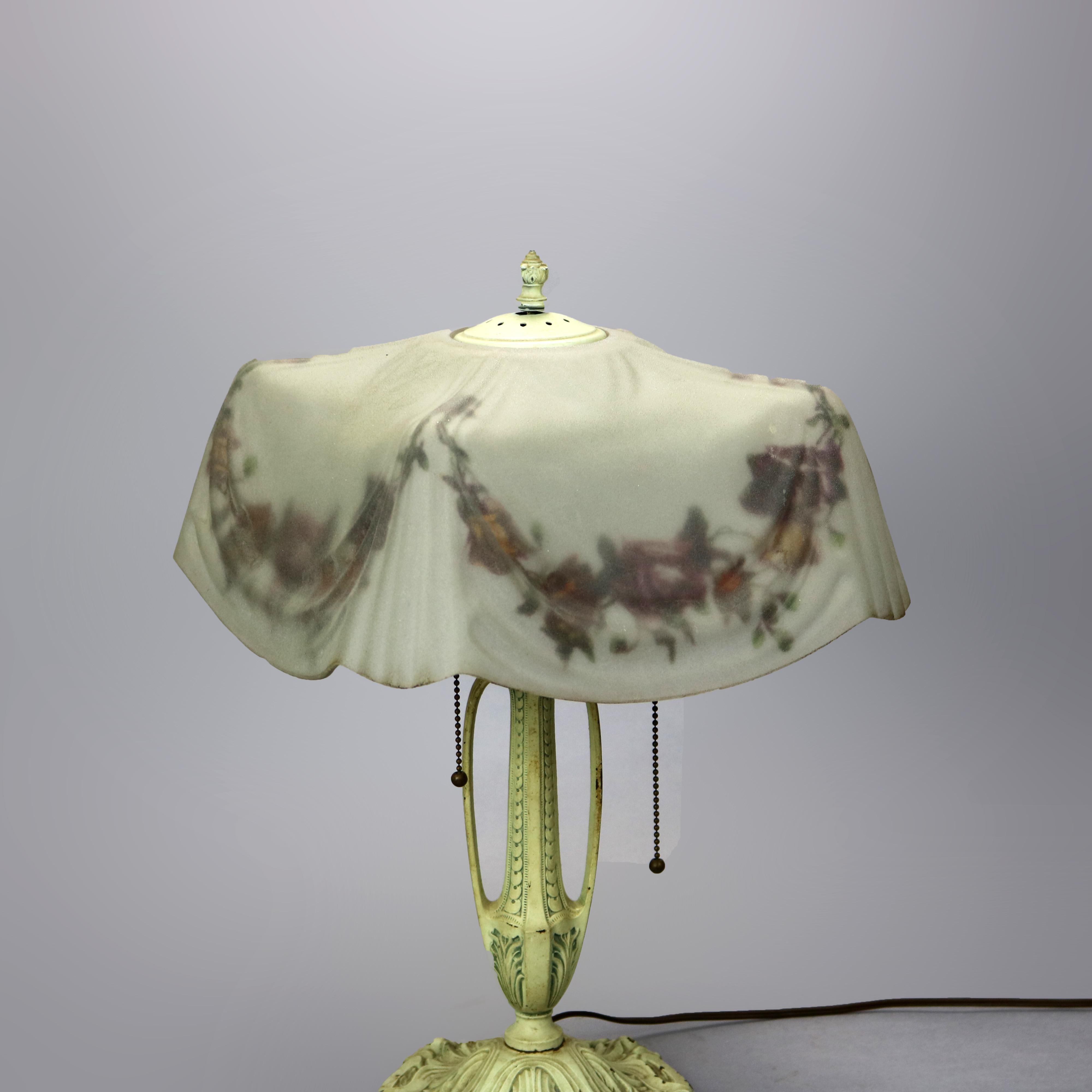 An antique Pittsburgh table lamp offers glass molded drapery form shade with reverse painted floral garland surmounting double handle urn form cast base with double sockets, c1910

Measures: 20