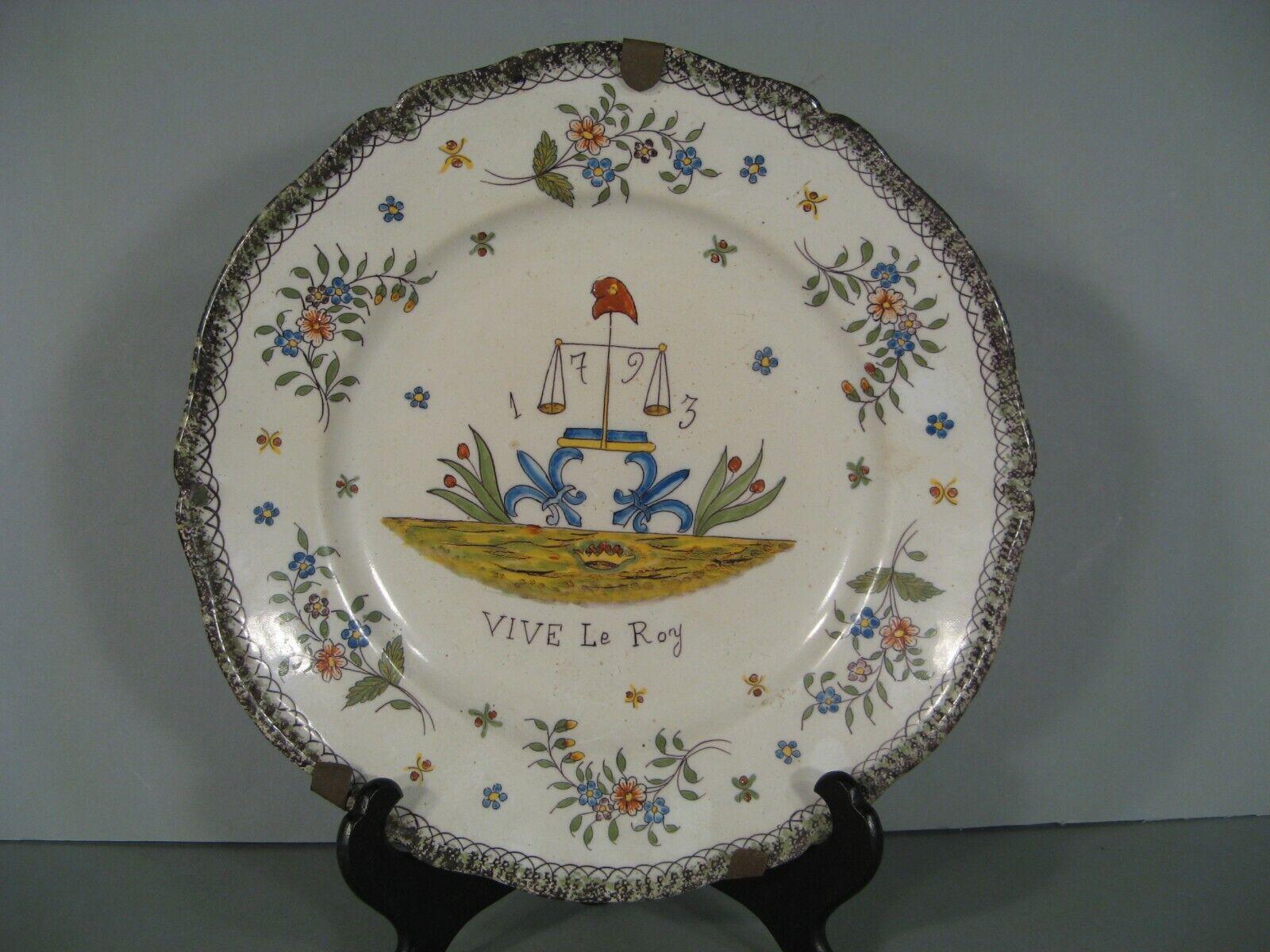 This antique faience plate by the renowned Fourmaintraux Desvres manufactory features a vibrant polychrome decoration. The design includes fleur-de-lis, scales, a Phrygian cap, floral elements, and the date 