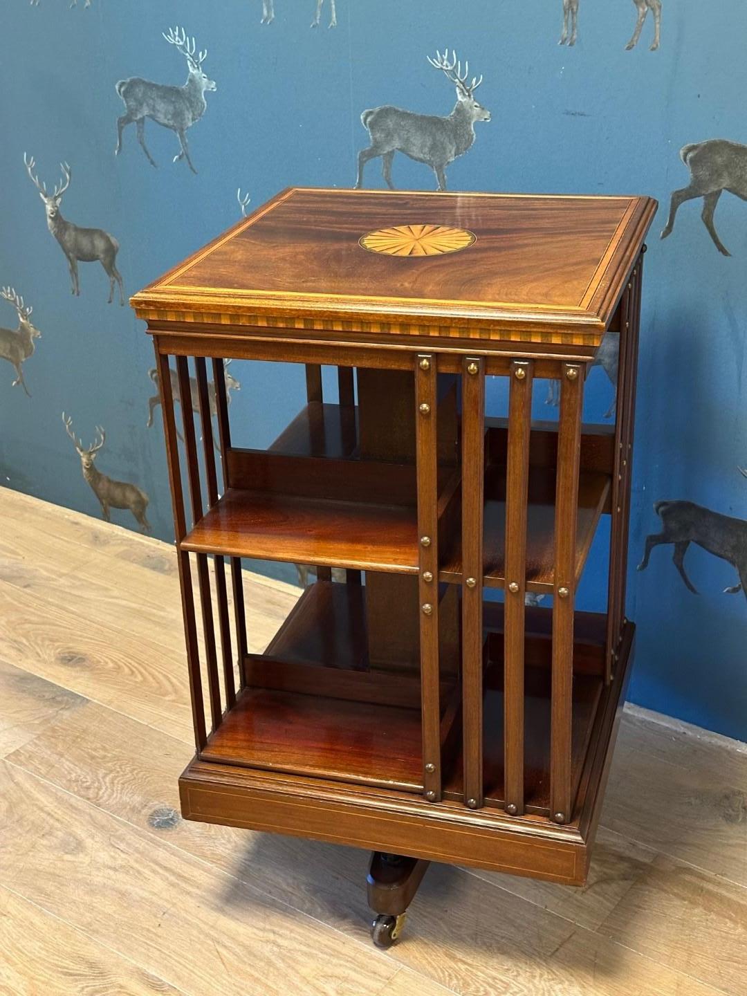 Beautiful antique  revolving bookcase with beautiful inlay. Inlaid with satinwood. Super quality from the famous English 19th century furniture maker Maple & Co. with the characteristic cast iron base. Beautiful color and appearance.

Origin: