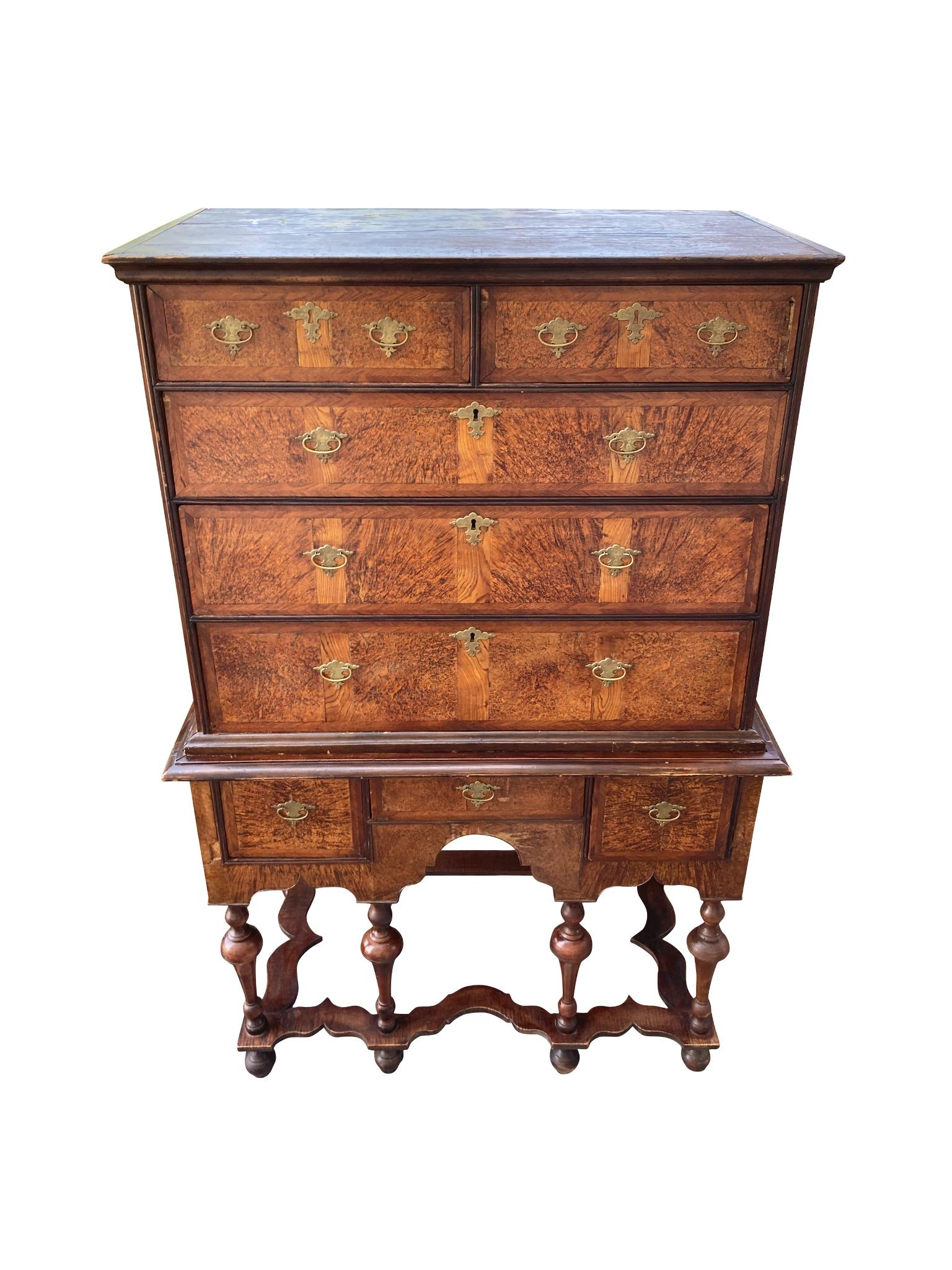 Handcrafted in the late 17th-early 18th century in Rhode Island, this two-part highboy typifies the William & Mary style with its combination of curved and linear forms. It's comprised of mahogany wood with burled walnut veneer. The upper half