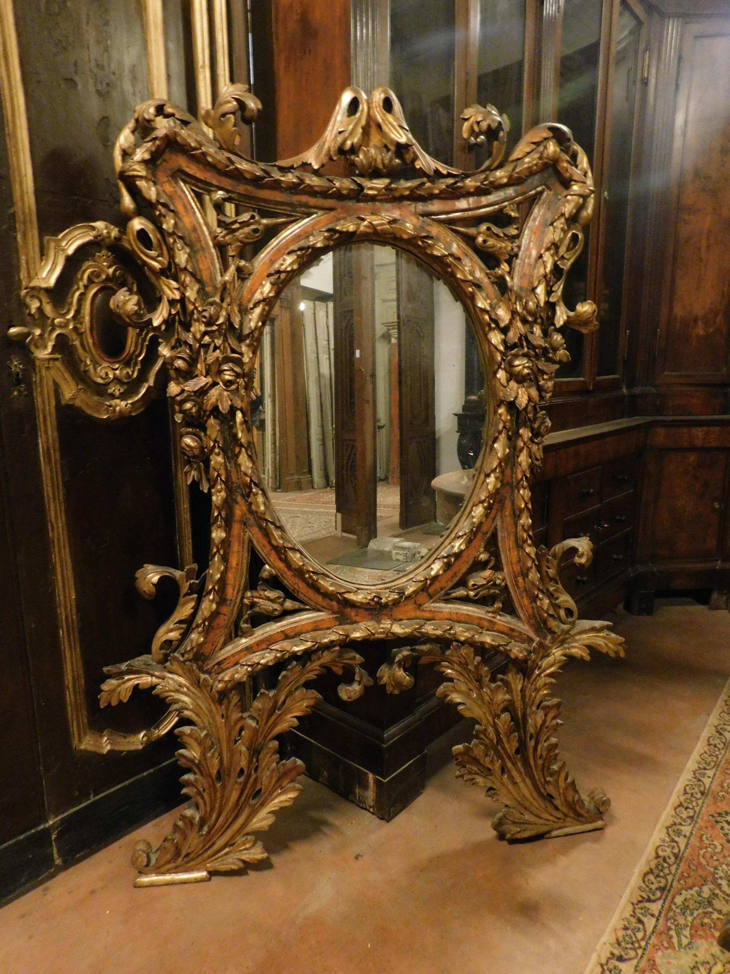 Miroir ancien doré à la mecque, sur Bolus rouge, avec de très riches sculptures faites à la main représentant des feuilles et des volutes, du début du dix-huitième siècle, provenant d'un important palais en Italie.
En bon état de conservation,