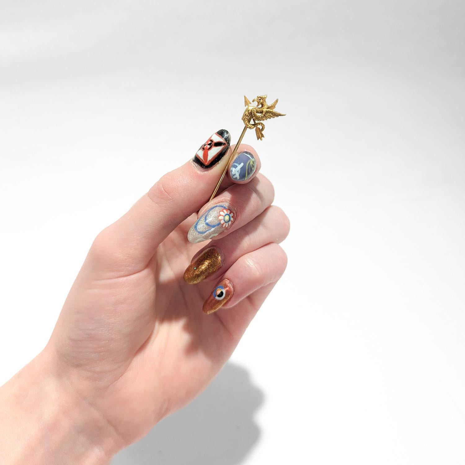 A fine antique figural stickpin.

In 14k yellow gold.

In the form of a dragon with a ruby eye and intertwined with an arrow.

Marked to the reverse for with the Riker Brothers' maker's mark and 14k.

Simply a wonderful signed stickpin!

Date:
20th