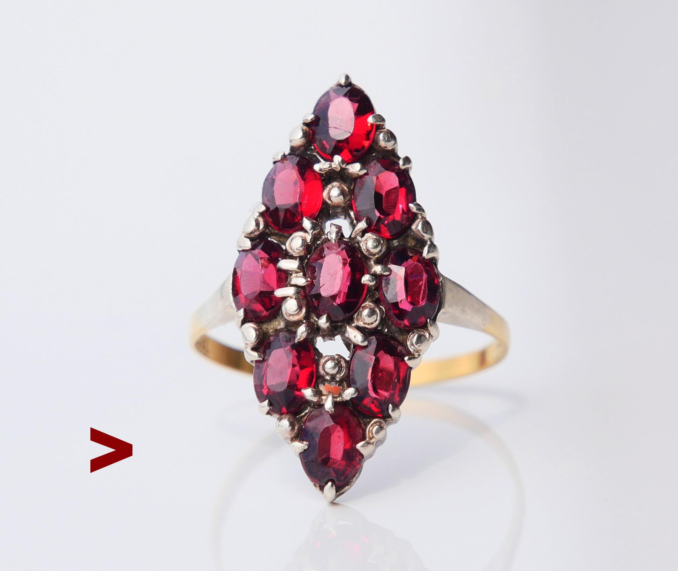 Old ring with band in solid 18K Gold and navette / boat shaped crown likely in Silver measuring 23 mm x 12 mm x 4 mm deep set with nine oval cut Red Bohemian Garnets 5 mm x 3.5 mm / ca 0.3ct each or 3ct total weight. 

Likely German or Austrian,