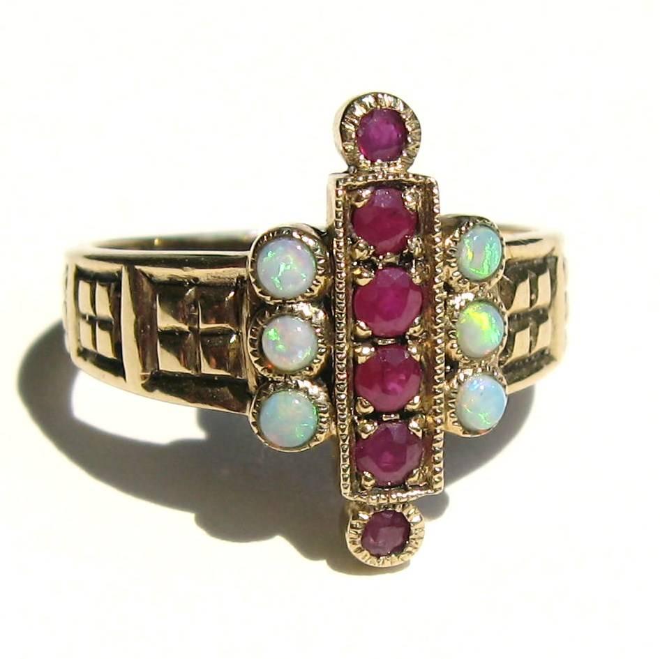 Stunning English Ruby & Opal Ring. Opal have nice fire to them, bezel set. 6 Prong set Rubies. Hallmarked English. This also has another set of hallmarks looks like AK. Ring is a size 7.5 and can be sized by us or your jeweler. This is out of a