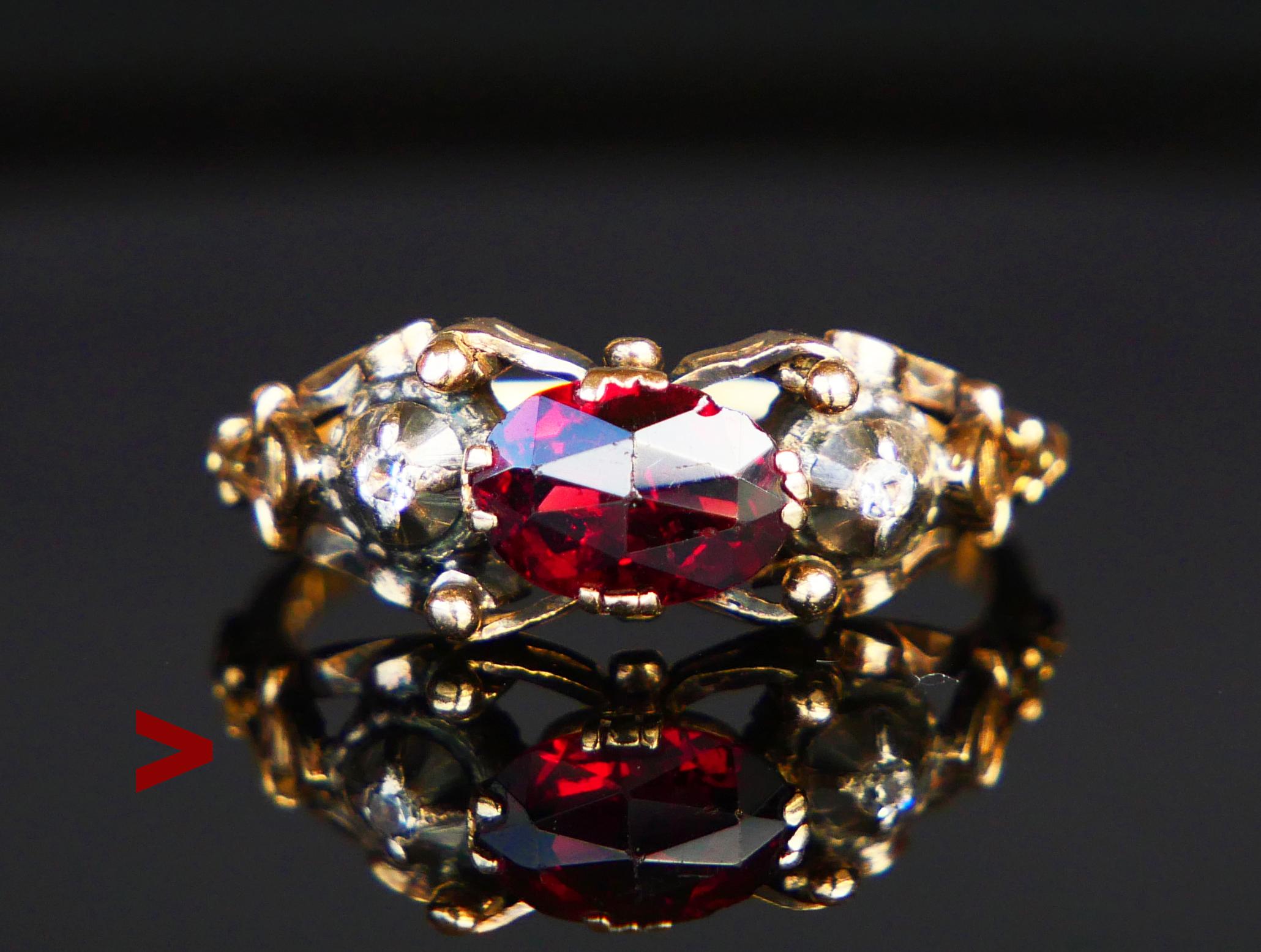 Nordic Renaissance-styled ring with carved band in solid 18K Yellow Gold. Claw set Natural oval rose cut Garnet with open back 8mm x 5.5mm x 3.3 mm deep / ca. 1.5 ct and flanked with two old diamond cut Diamonds in round Silver clusters with closed
