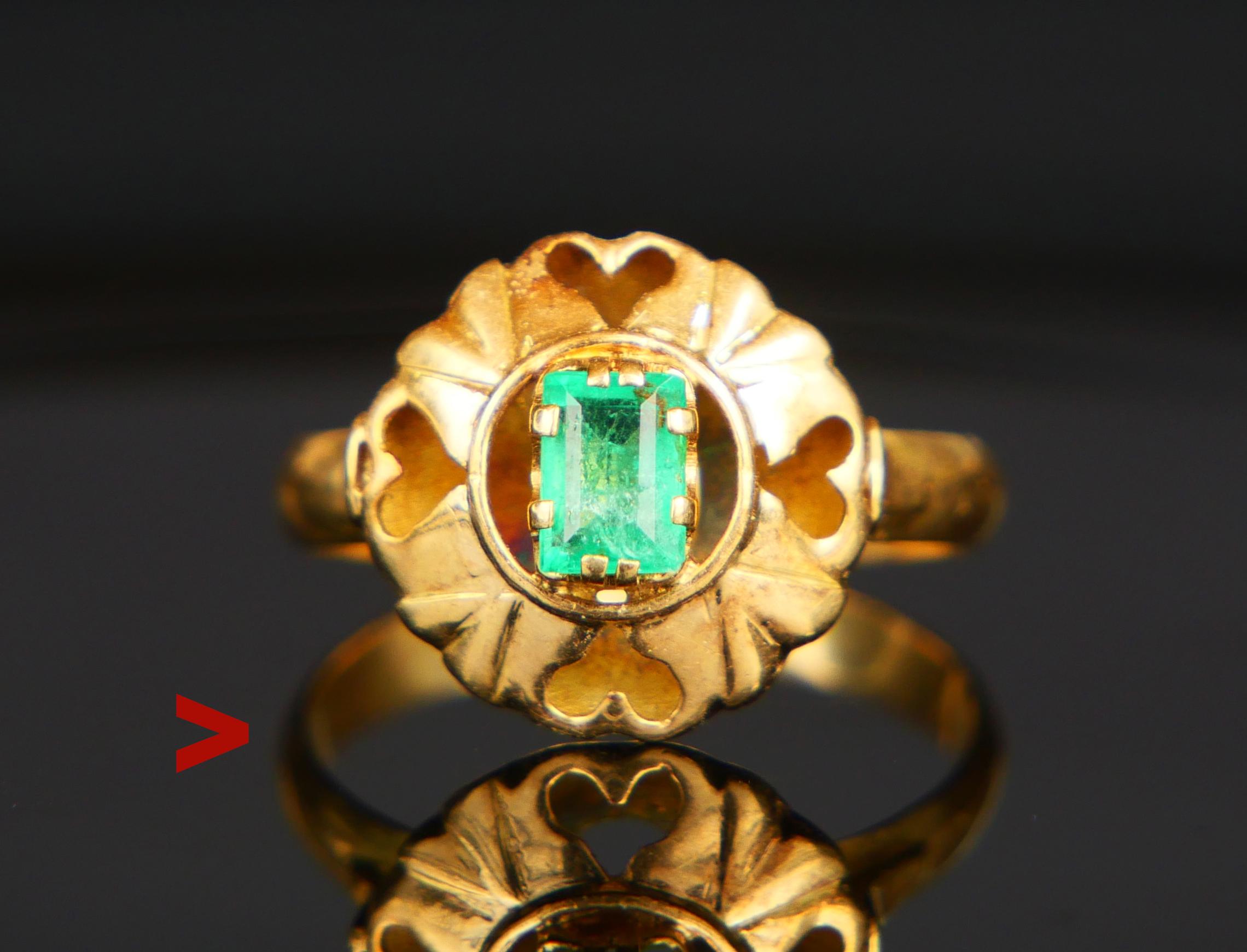 A Ring with band in solid 18K Yellow Gold with open work crown decorated with 4 hearts featuring claw set natural bright Green Emerald 6 mm x 4 mm x 3mm deep / ca. 0.6 ct with open back. Stone with natural flaws and inclusions.

No hallmarks, 18K .