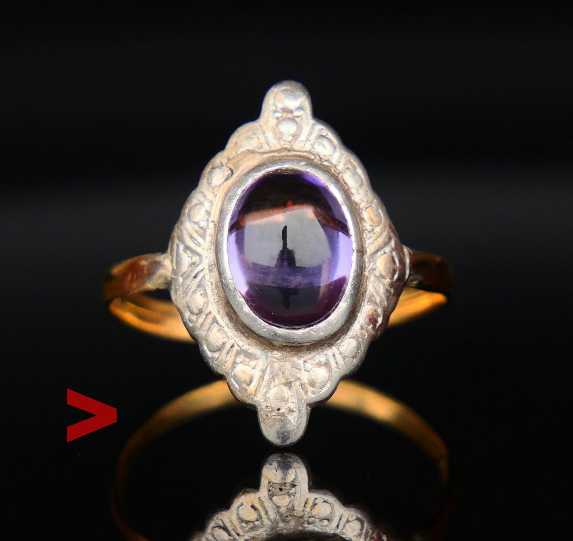 A ring from ca 1910s-1930s with navette - shaped Silver crown 20mm x 12mm decorated with cabochon cut lab made Purple/ Sapphire stone 10 x 8 x 4 mm / ca 3.5 ct that seems to change color a bit under different light. Band in solid 18K Yellow Gold,