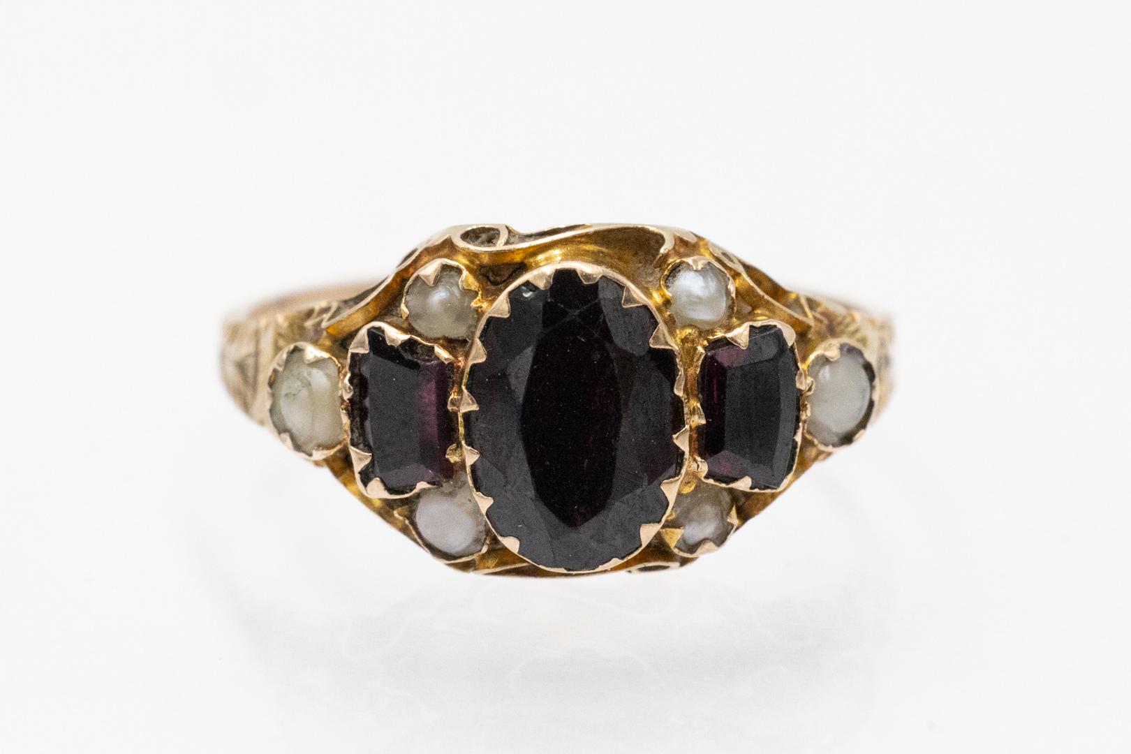 Bague ancienne en or avec grenats et perles naturelles, Grande-Bretagne, début du XXe siècle.

En or jaune 9 carats (0,375)

Serti de trois grenats ovales taillés à facettes et de perles naturelles, le bracelet est orné d'une belle gravure