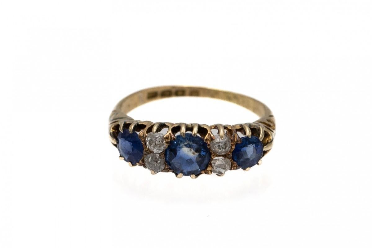 An old ring made of 0.750 yellow gold with three round sapphires and four diamonds.

4 brilliant-cut round diamonds weighing approx. 0.20 ct (colour G-I clarity I1) and 3 faceted sapphires weighing 1.30 ct

Made in England, in London in the