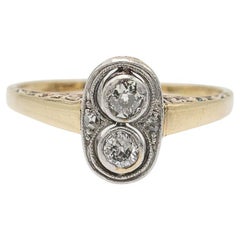 Antique ring with two 0.20ct diamonds and floral engraving, 1930s.