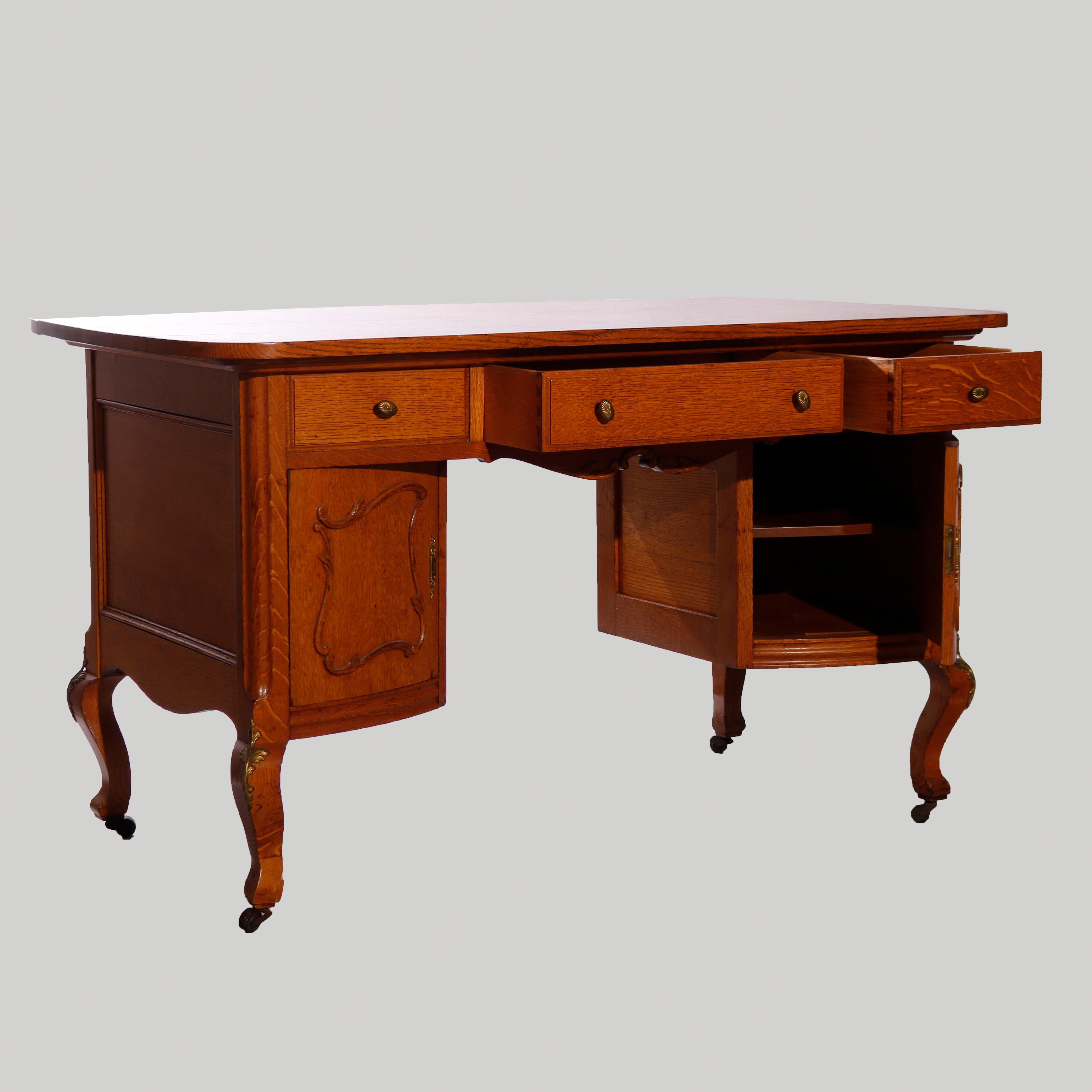 An antique RJ Horner partners desk (double sided allowing two people to work at the desk simultaneously) offers quarter sawn oak construction with upper drawers over flanking curved side cabinets having foliate carved elements and opening to shelved