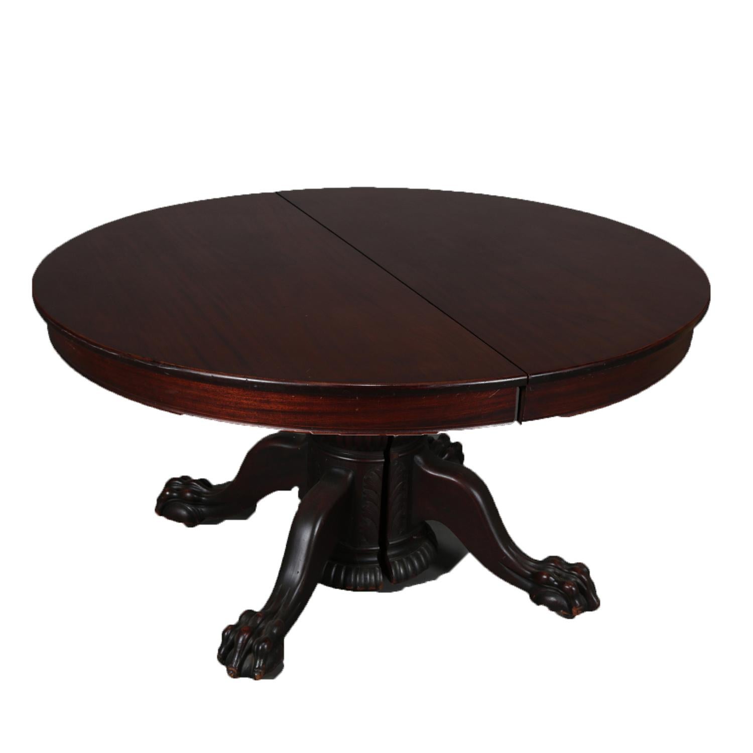 An antique R.J. Horner School dining table features mahogany construction having split foliate carved pedestal and raised on claw and ball feet, includes four leaves, circa 1910.

Measures: 30