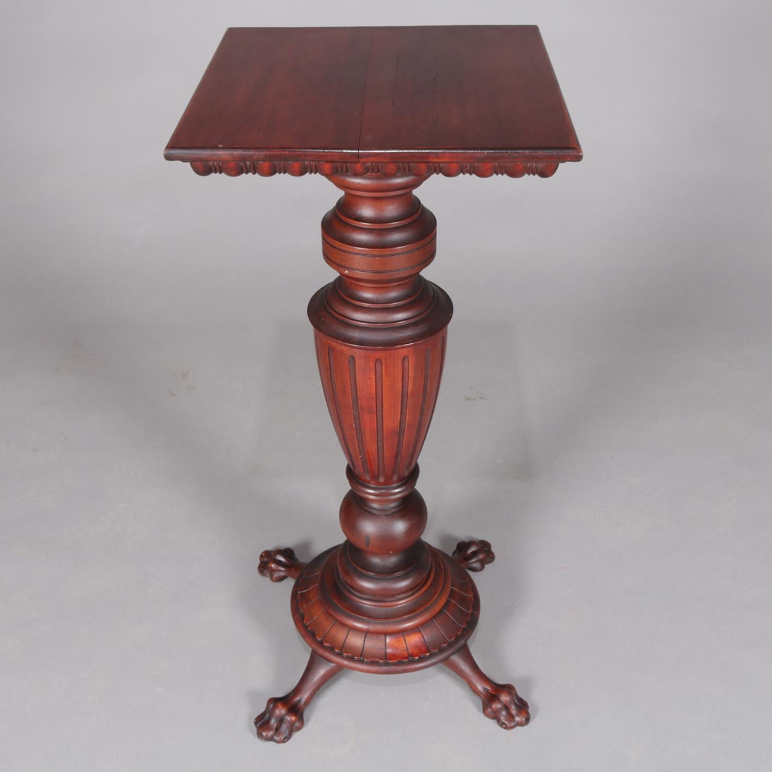 An antique R.J. Horner School sculpture pedestal features carved mahogany construction with display having beaded border surmounting reeded urn form pedestal raised on paw feet, circa 1920.

Measures: 35.75