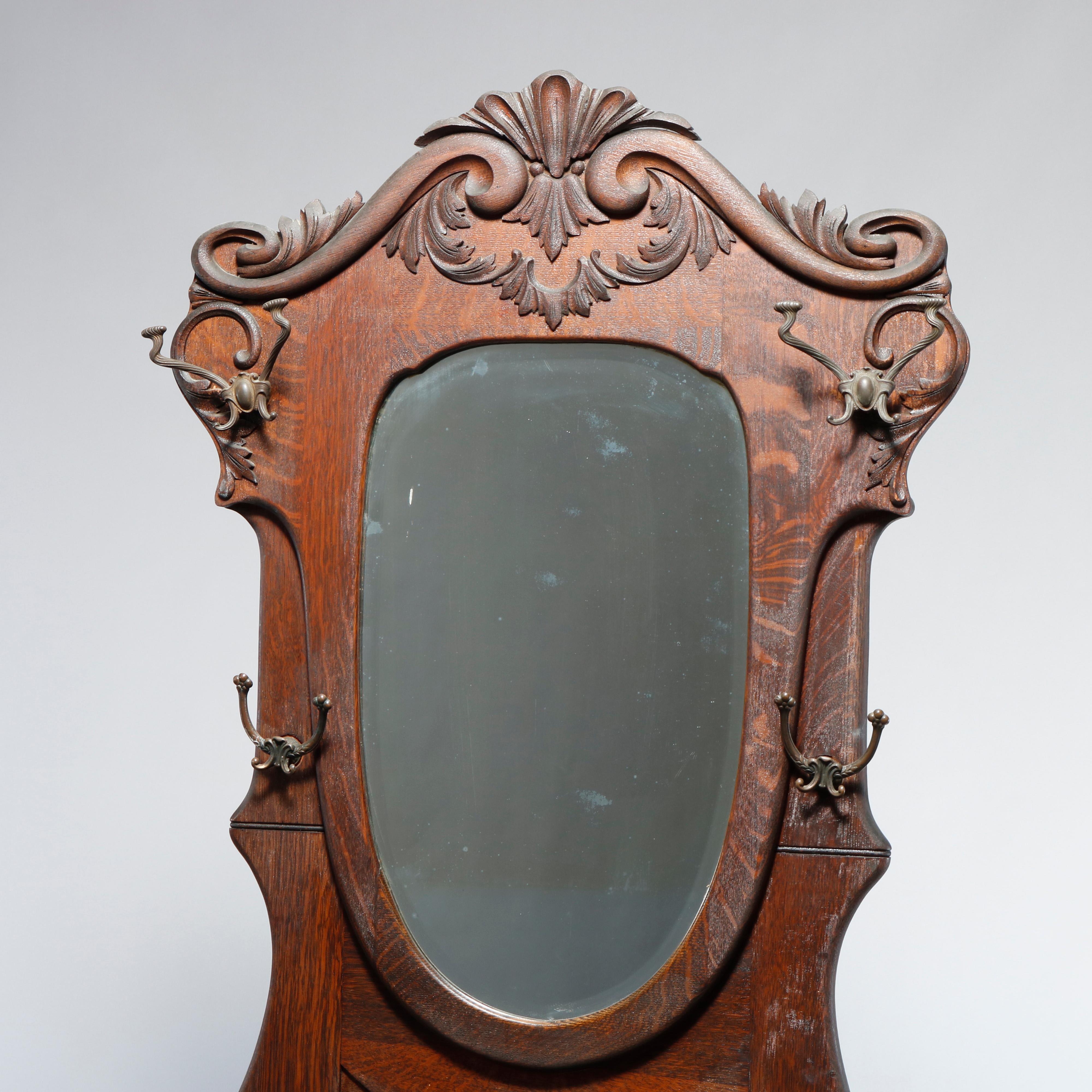 An antique hall seat in the manner of RJ Horner offers oak construction with shield form mirror having frame with carved scroll and foliate elements and surmounting lift top seat with flanking arms, c1910.

Measures: 82