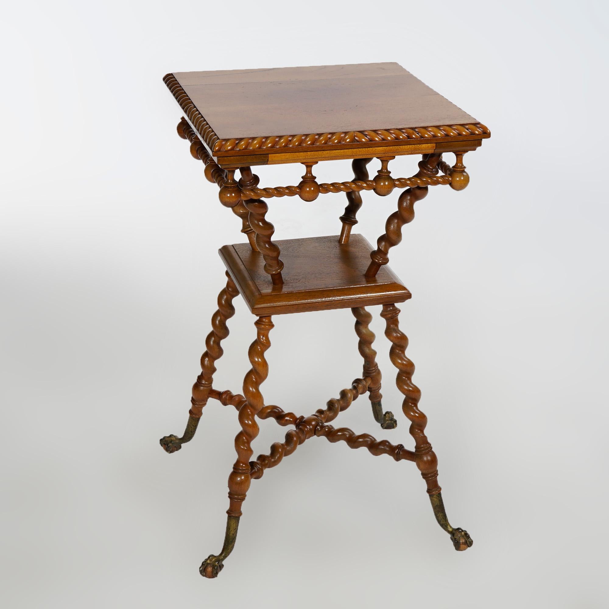 An antique parlor table in the manner of RJ Horner offers carved walnut construction in hourglass form with beveled top having rope twist border, raised on barley twist legs with lower display and terminating in claw and ball feet, c1900

Measures-