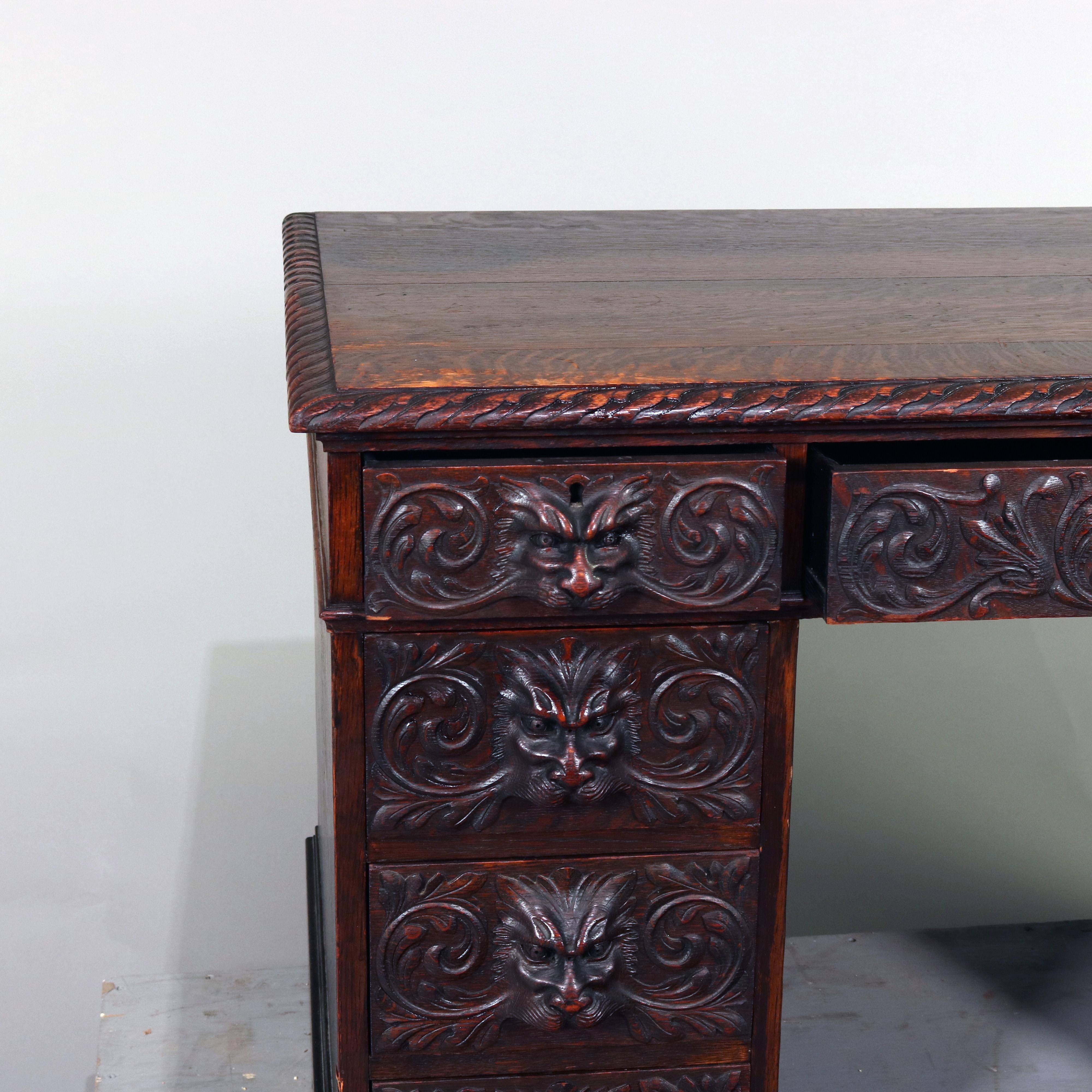 Antique R.J. Horner School knee hole campaign desk features deeply carved oak construction with rope twist top surmounting central drawer with flanking drawer columns, each deeply carved with mask and foliate decoration, reminiscent of Black Forest,