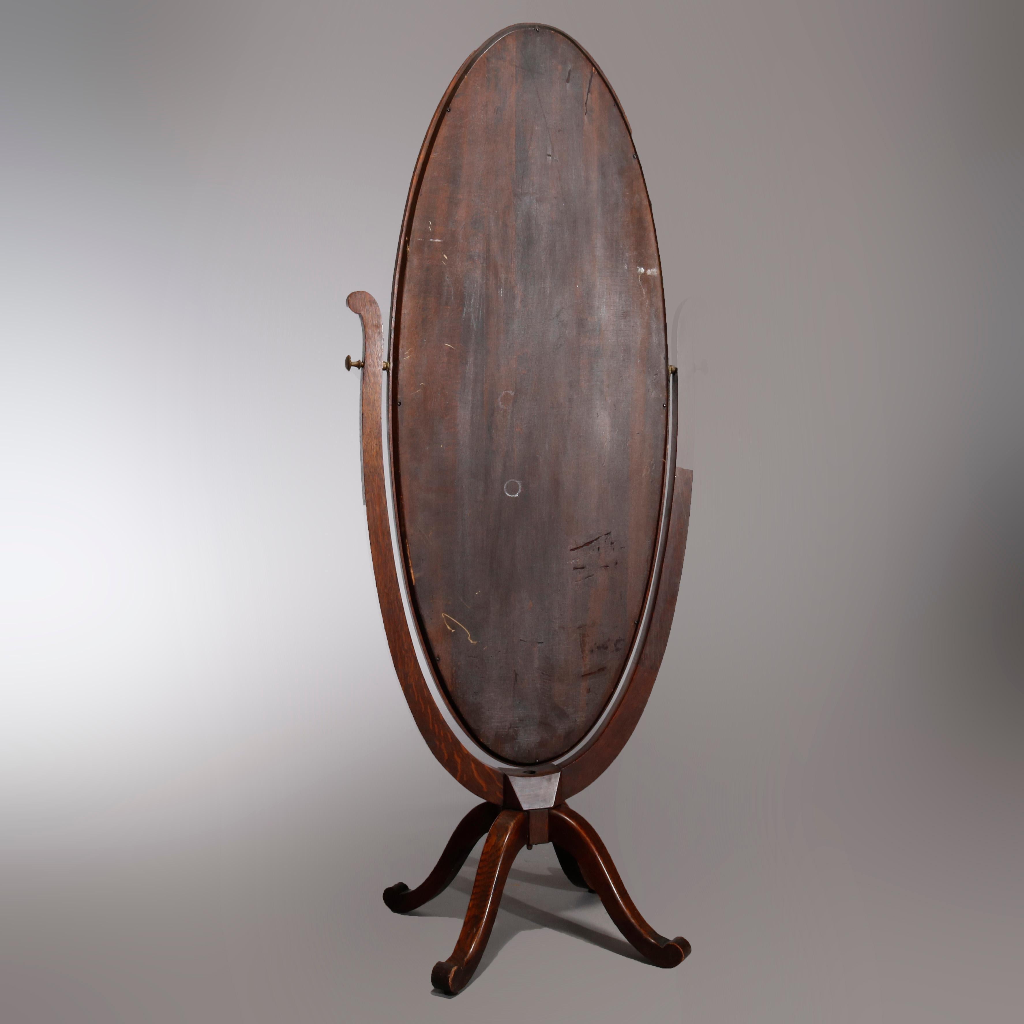 An antique cheval dressing mirror in the manner of R.J. Horner offers oak frame with oval mirror raised on quadruped base with cabriole legs, circa 1900.

Measures: 70.5