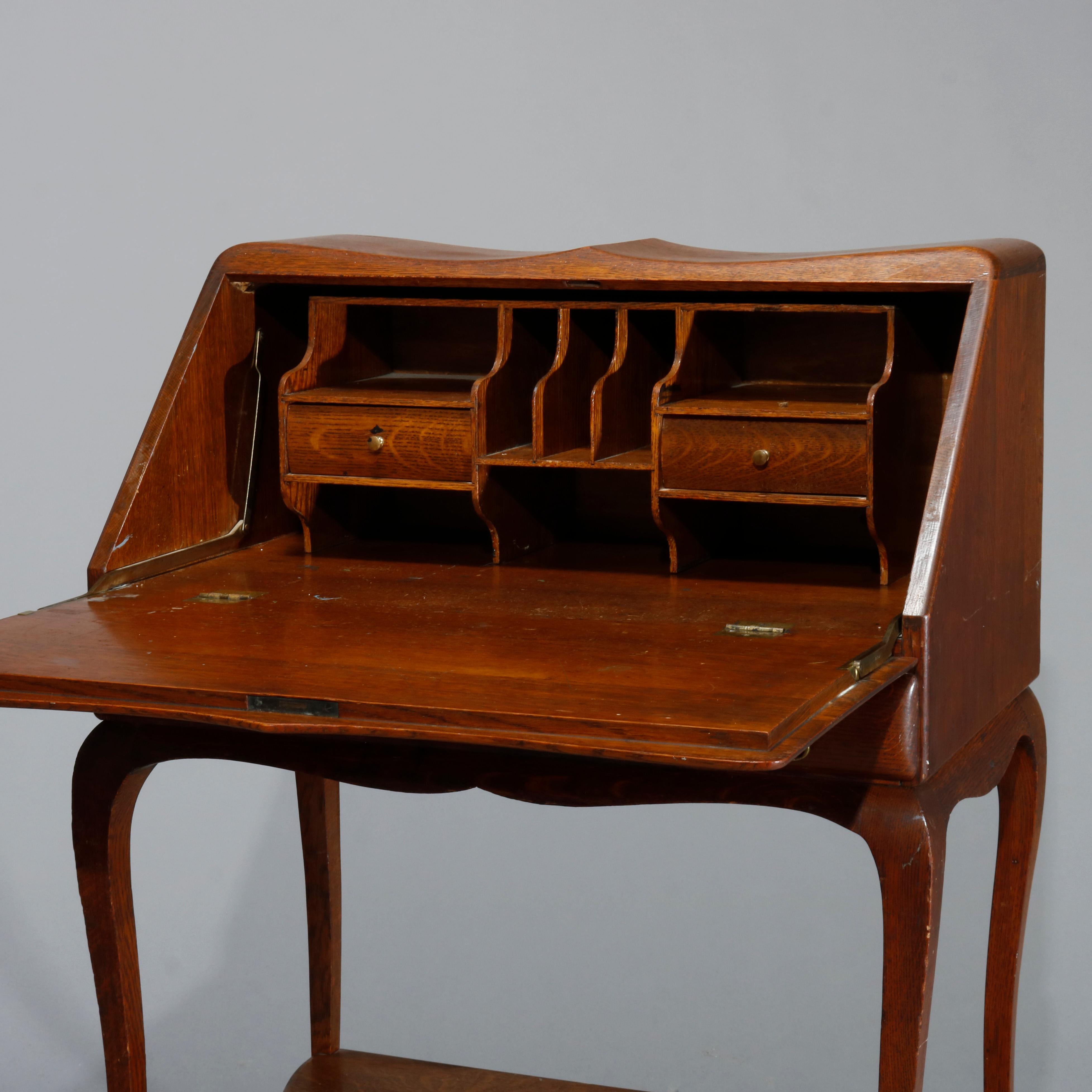 An antique ladies writing desk in the manner of RJ Horner offers quarter sawn oak construction with shaped case having slant drop-front desk over single long drawer and raised on cabriole legs having lower shaped shelf, c1910.

Measures: 39.5