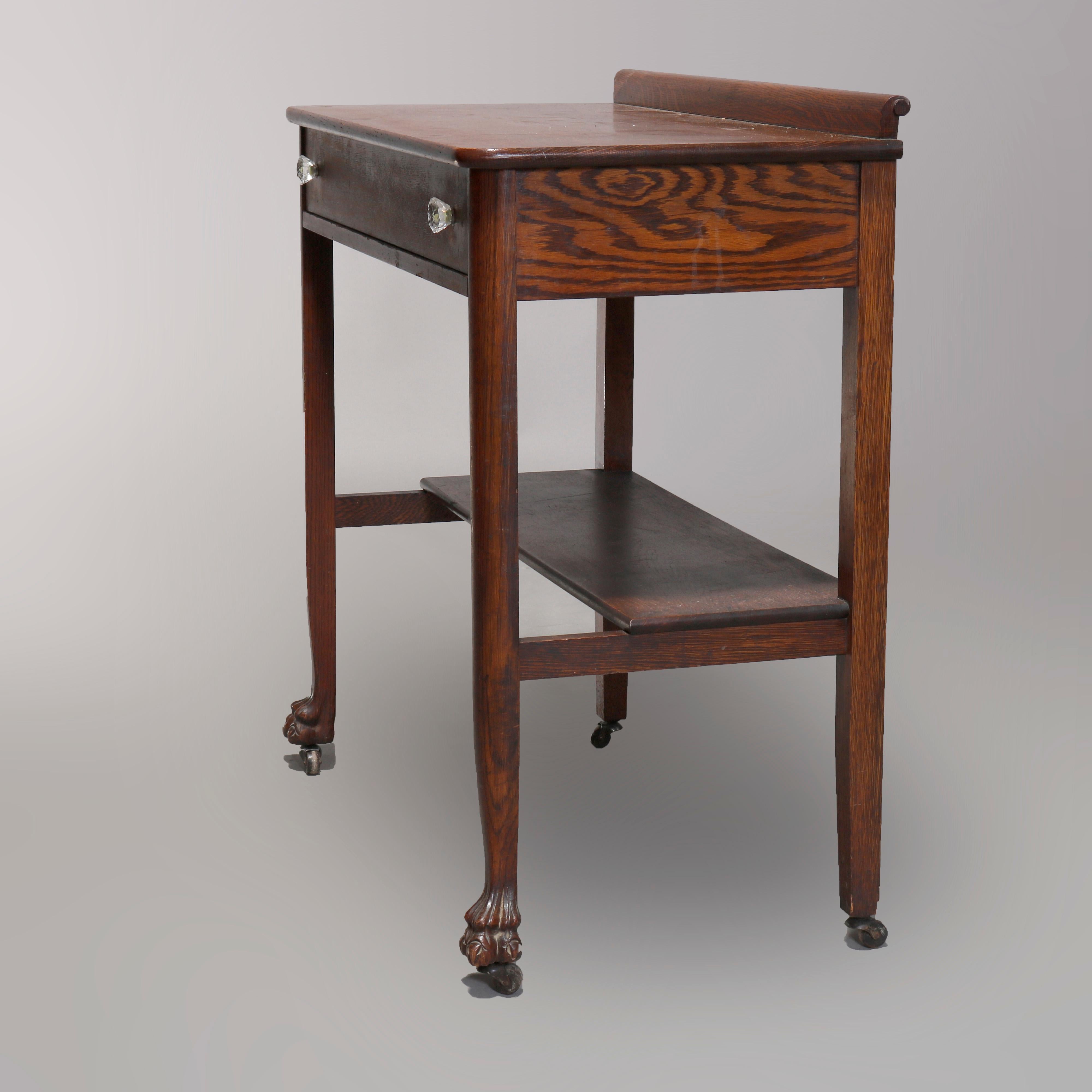 An antique server in the manner of R.J. Horner offers oak construction with backsplash surmounting single drawer case having lower shelf and carved paw feet, circa 1900.

Measures: 34