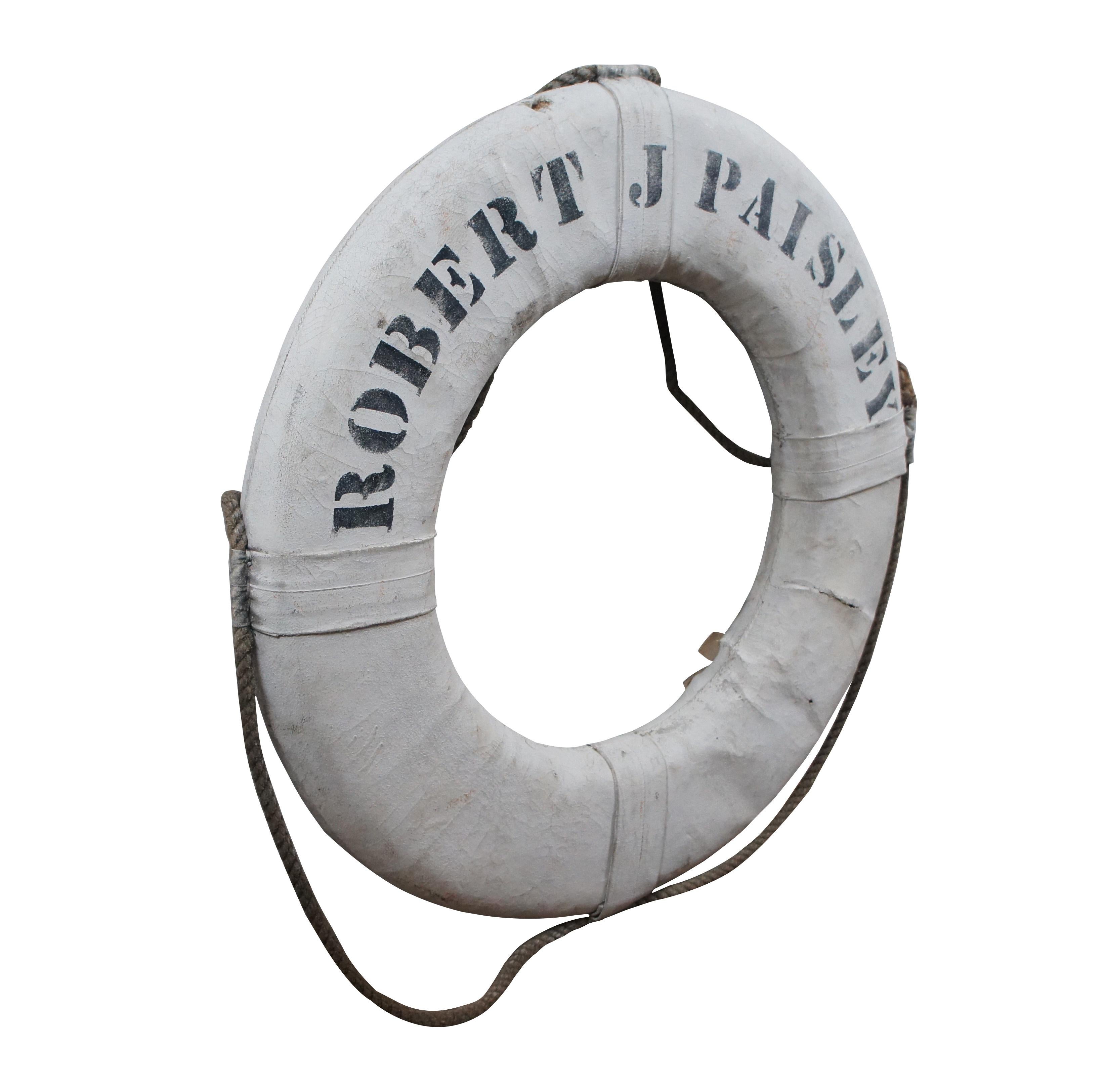 Antique Robert J. Paisley boat life preserver buoy saftey ring featuring a hard foam core with a white painted canvas cover and hemp rope handles. 

