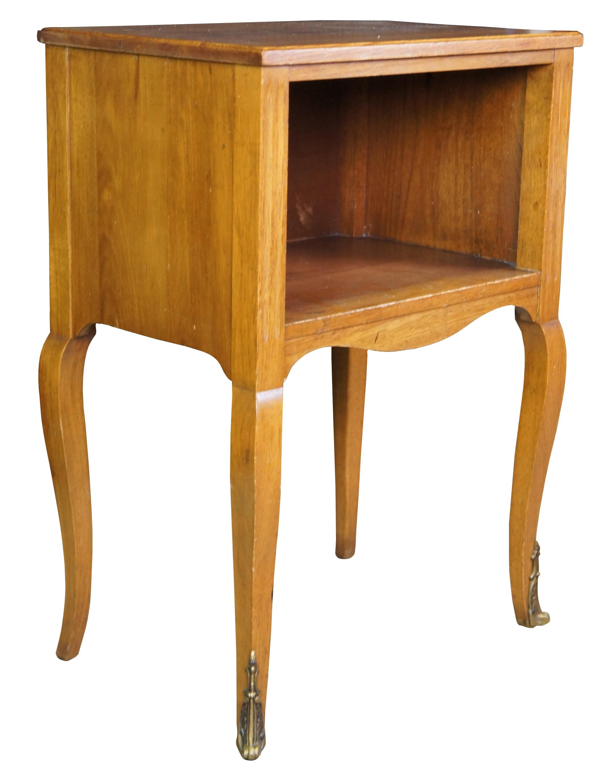 A lovely nightstand or accent table by Robert W. Irwin Furniture Company.  Crafted from French Walnut in Louis XV styling.  Features a rectangular form with open cubby flanked by fluted stiles, serpentine apront and long cabriole legs with ormolu