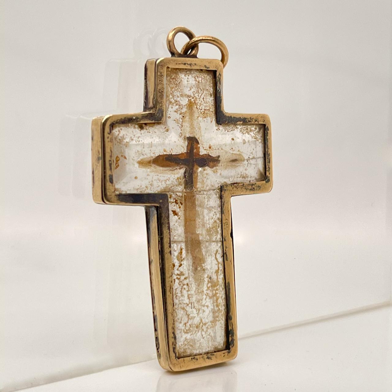 A very fine antique rock crystal & 14k gold cross or crucifix. 

The rock crystal has an interior chamber that appears to be carved out and hold dark splinters. We assume this is a relic.

The rock crystal itself is bezel set in 14 karat gold.  

By