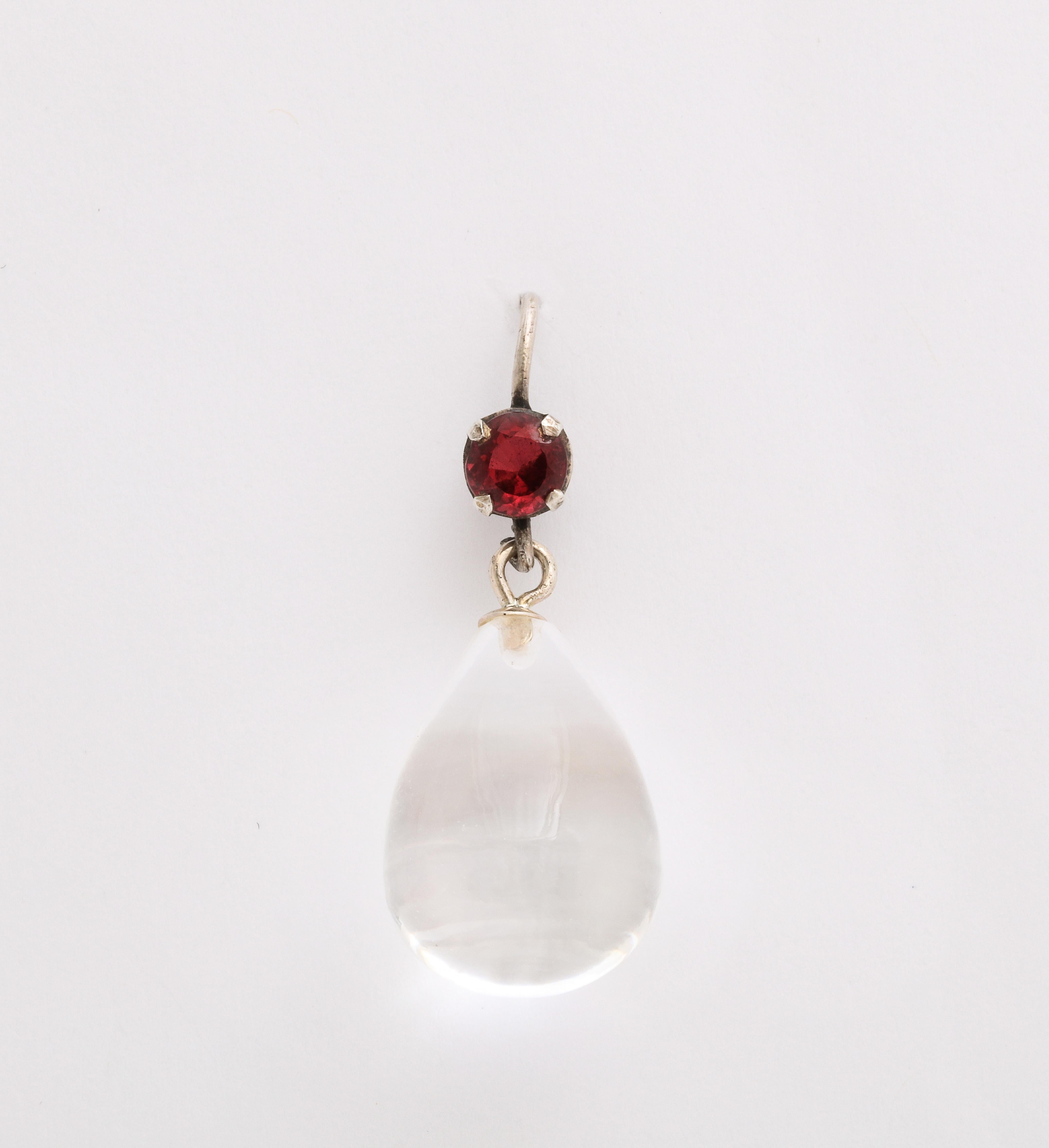 The many who appreciate the qualities of rock crystal will delight in these sterling set rock crystal earrings. An ovoid clear crystal is topped by a round garnet. The color combination is perky. Wear them day, night and always. Rock crystal is