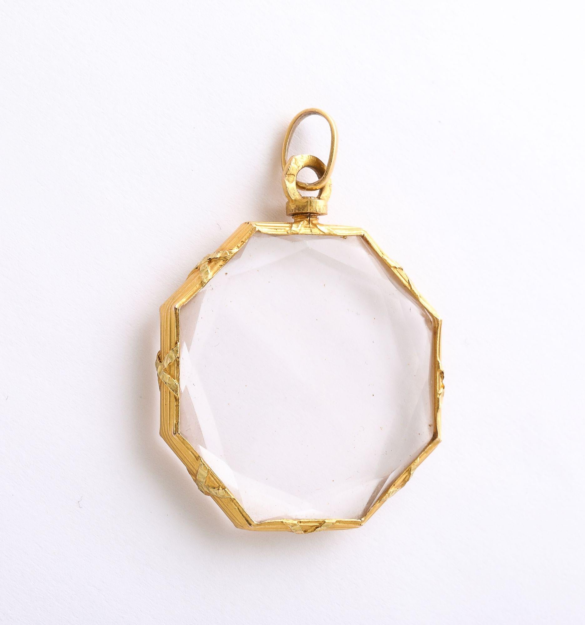 A wonderful Antique Rock Crystal Octagonal PenLocket with faceted crystal surrounded by a gold frame with repose' design.  The locket has a screw feature that needs to be disassembled to fill with a photo, flower or small
diamonds which can be