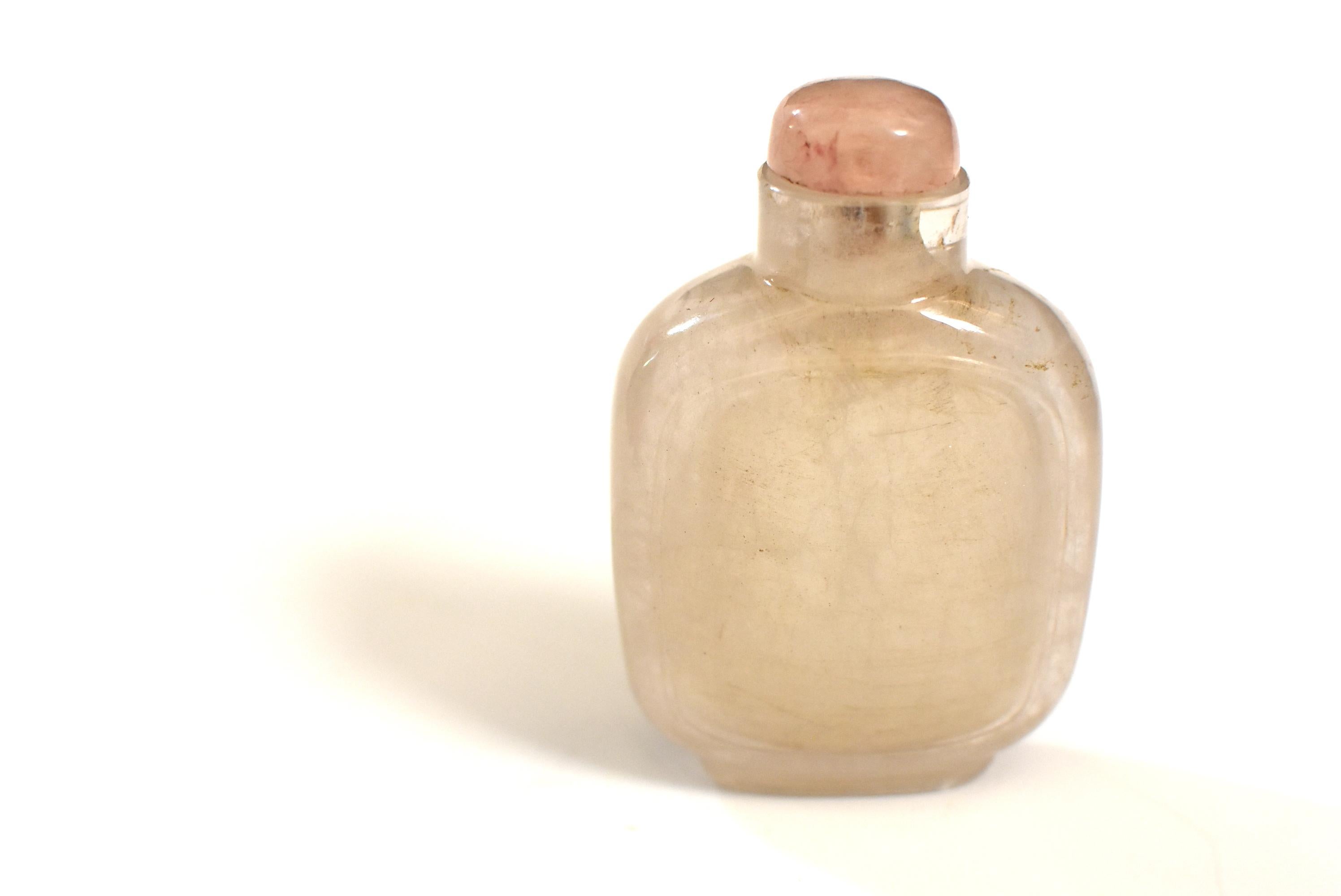 A beautiful 19th century natural rock crystal Chinese snuff bottle. Carved on both sides an oval cartouche enclosing none other than the precious mineral stone itself. Elegant form and refined finish. Rose quartz stopper. An internal small fissure