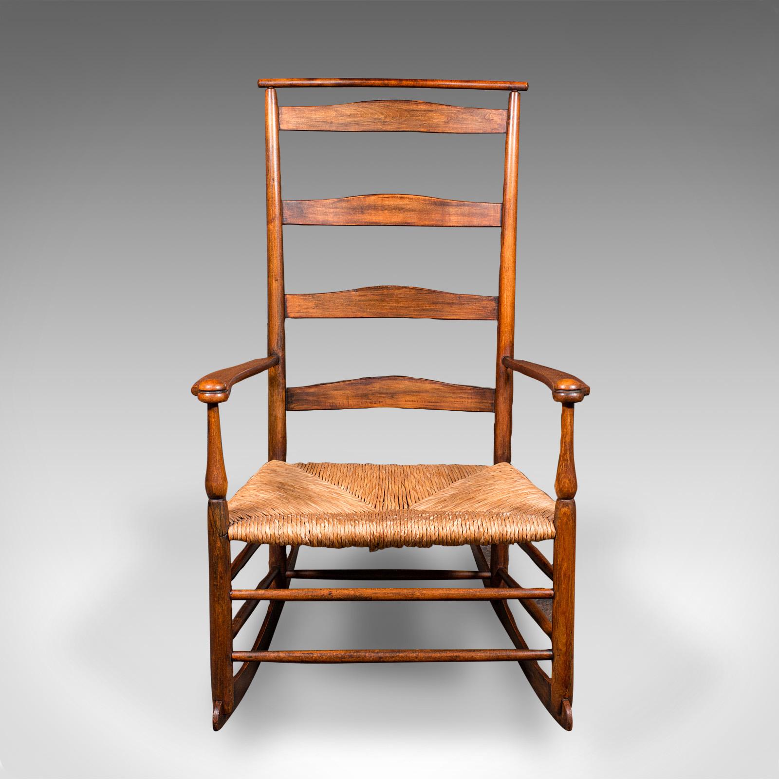 This is an antique shawl back rocking chair. An American, ash and pine rocker crafted by The Shakers of Mount Lebanon, dating to the Edwardian period, circa 1910. A beautifully preserved example of the revered Shaker Number 7 rocking chair, offering