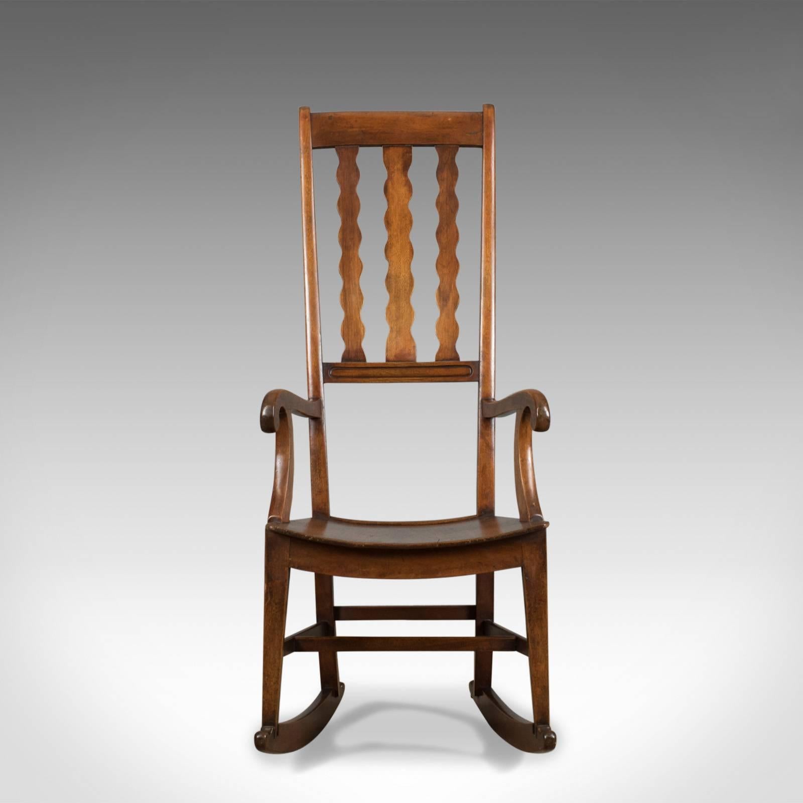 This is an antique rocking chair, an English, Victorian, mahogany wavy line rocker dating to the mid-19th century, circa 1850.

Delightful high back, 'wavy line' rocker
Good consistent color throughout
Displaying grain interest with a desirable