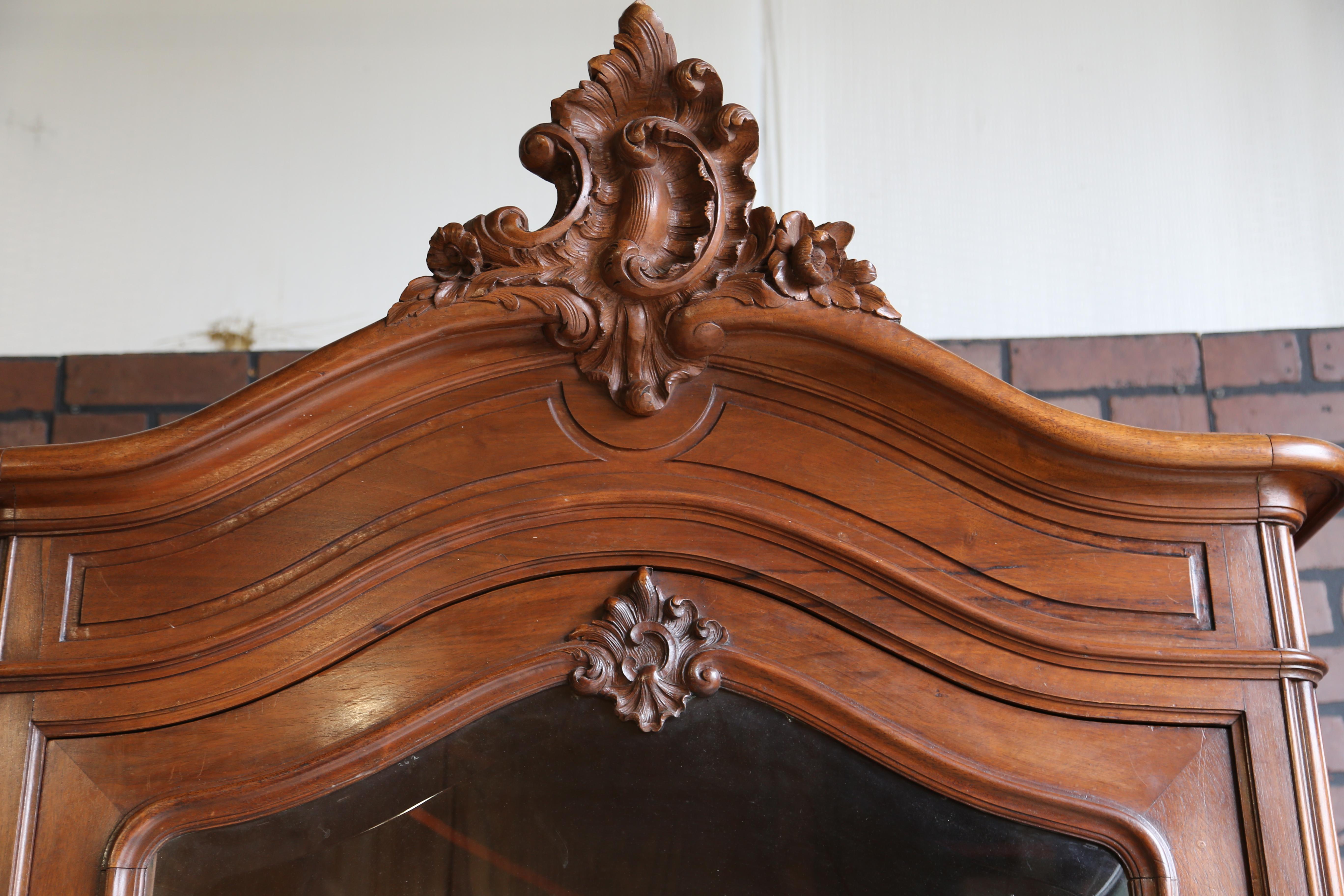 Antiker französischer Louis XV Rokoko-Schrank. Dieser Schrank ist in einem bemerkenswerten Zustand, wenn man sein hohes Alter bedenkt. Ein wunderschön geschnitztes Giebelfeld ziert die Haube. Der Spiegel wurde von der Türfront entfernt, um Glas zu