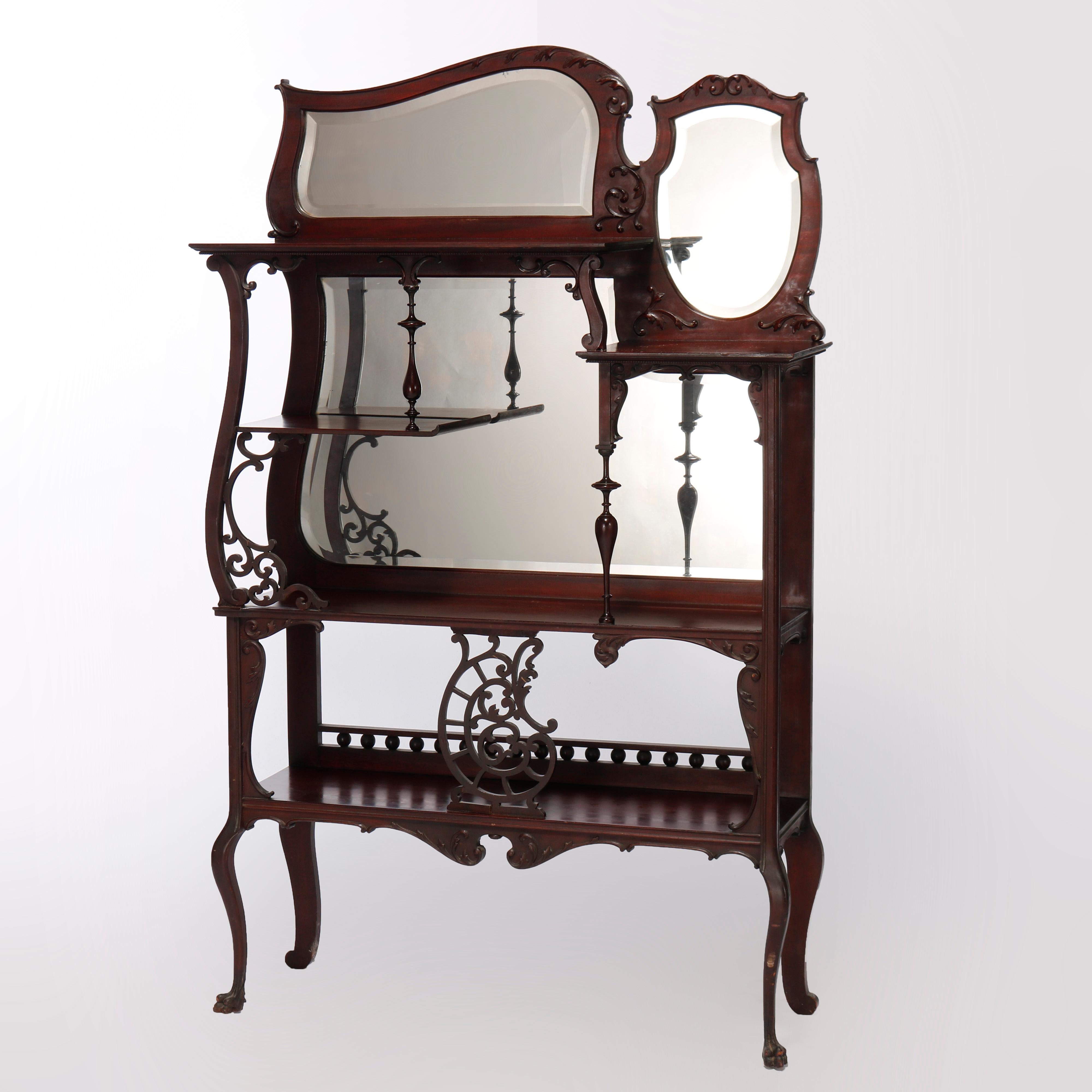 An antique Rococo etagere offers carved mahogany construction with beveled and shaped mirror over unit having offset shelving, mirrored back, pierced foliate filigree corbels and raised on cabriole legs, c1900

Measures - 64''H x 38.25''W x