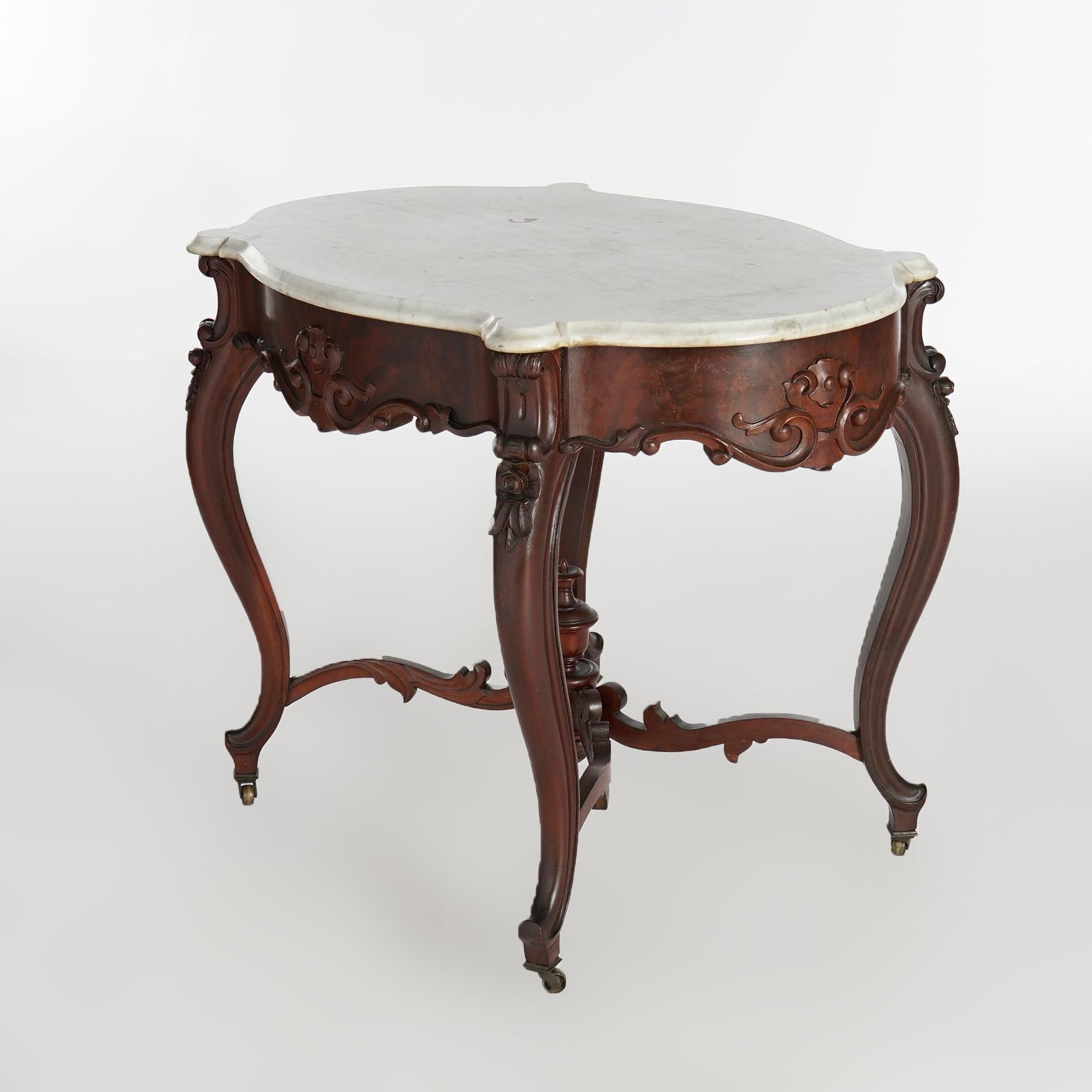 An antique Rococo parlor center table offers shaped and beveled marble turtle top over flame mahogany base having scroll and foliate elements, raised on cabriole legs with central urn form finial, c1880.

Measures- 29.5''H x 38''W x