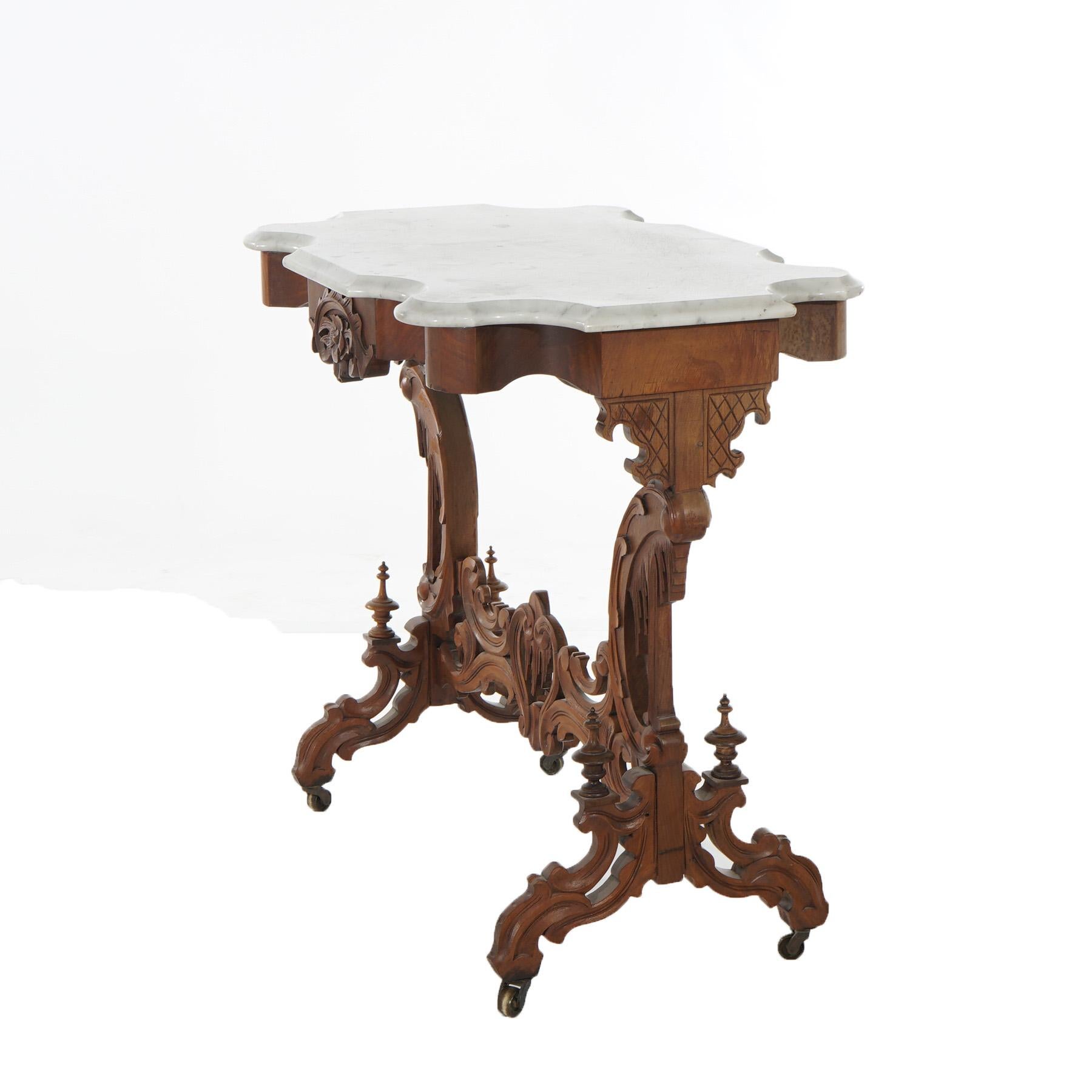 ***Ask About Reduced In-House Shipping Rates - Reliable Service & Fully Insured***
An antique Rococo into Gothic parlor table offers beveled and shaped marble top over walnut base having carved foliate, floral and Gothic elements throughout, raised